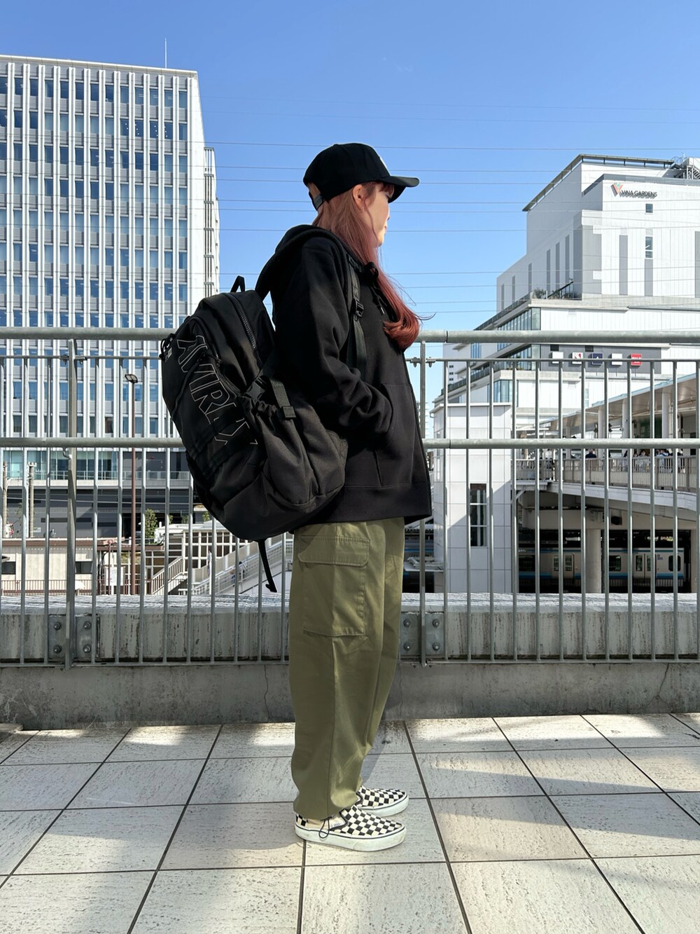 ブラック系のパーカー、ブラック系のバックパック/リュック、ブラック系のキャップを着用したレディースの春コーディネートの2枚目の写真
