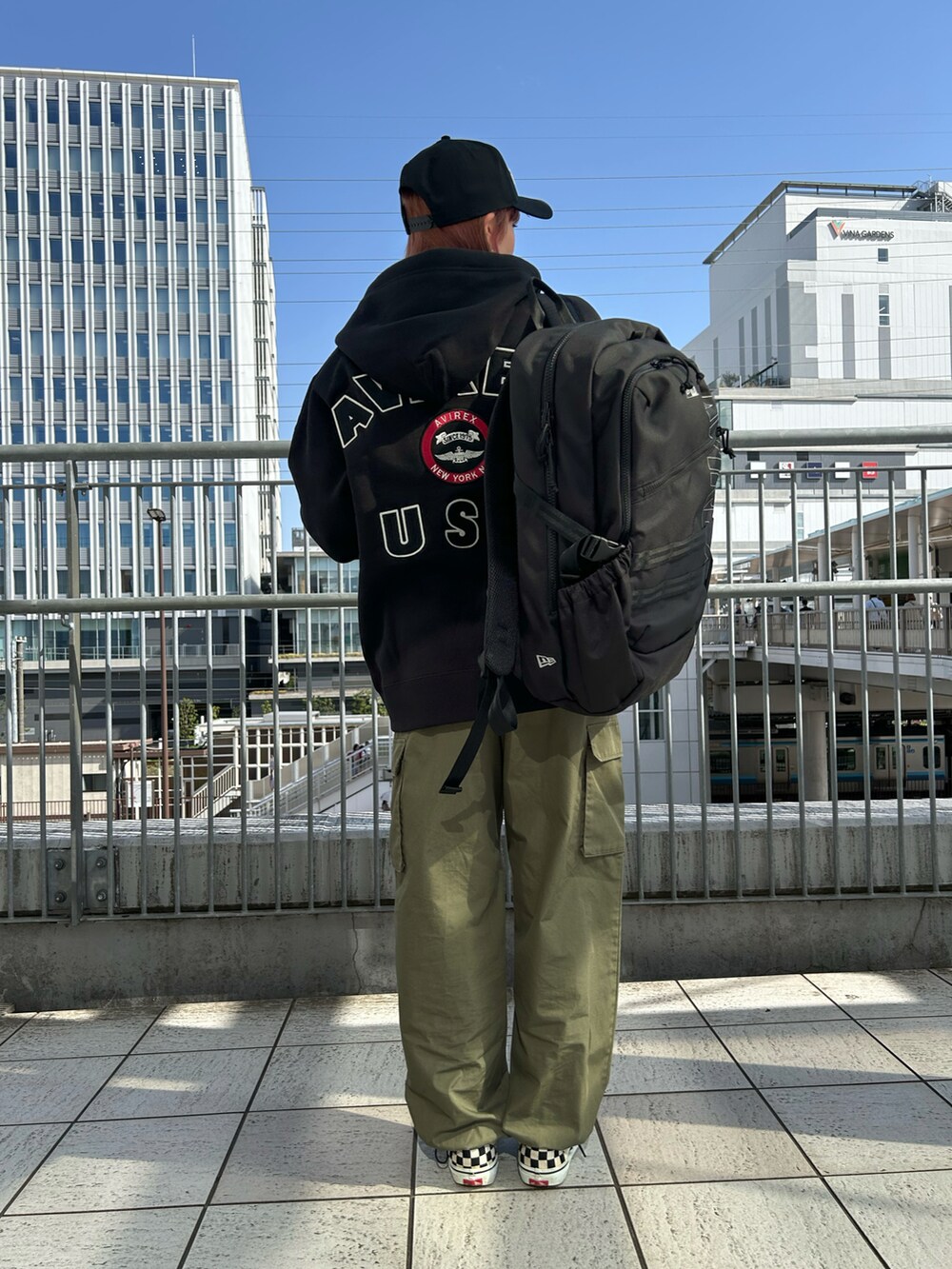 ブラック系のパーカー、ブラック系のバックパック/リュック、ブラック系のキャップを着用したレディースの春コーディネートの3枚目の写真