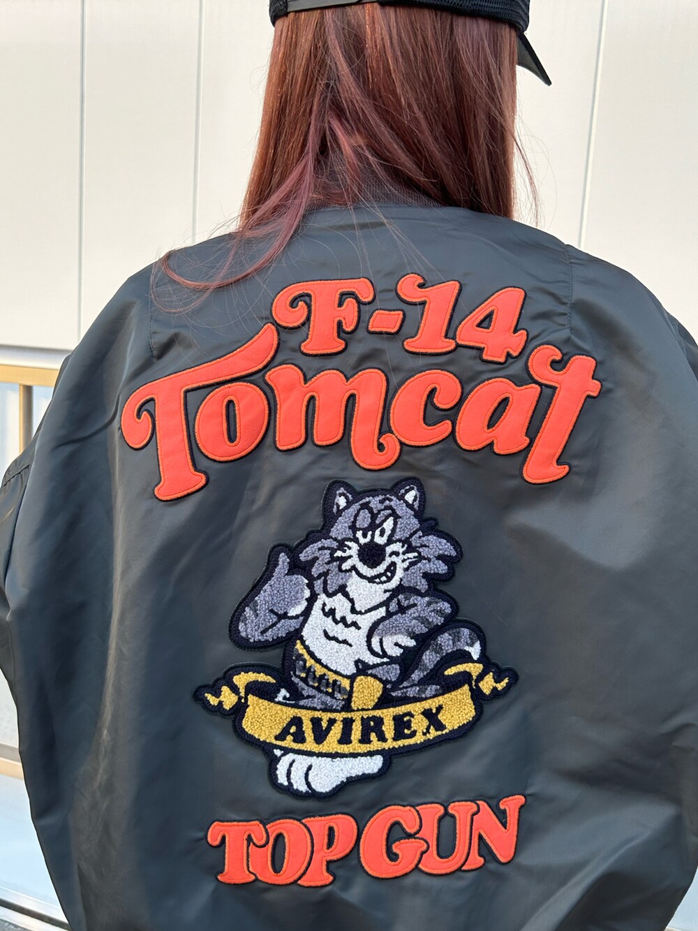 ホワイト系のTシャツ/カットソー、グリーン系のMA-1、ブラック系のキャップを着用したレディースの秋コーディネートの3枚目の写真