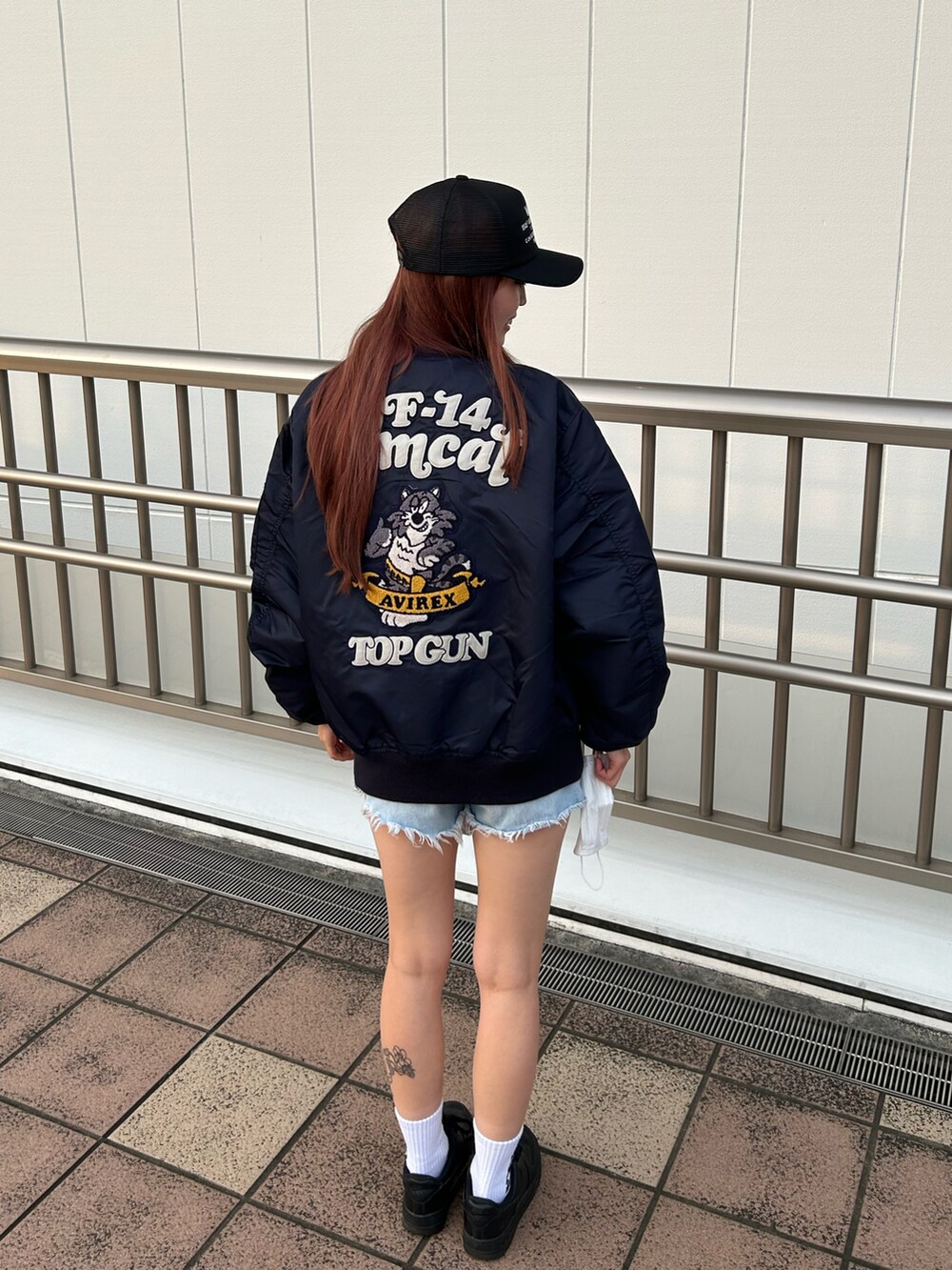 ホワイト系のTシャツ/カットソー、ブルー系のMA-1、ブラック系のキャップを着用したレディースの秋コーディネートの2枚目の写真