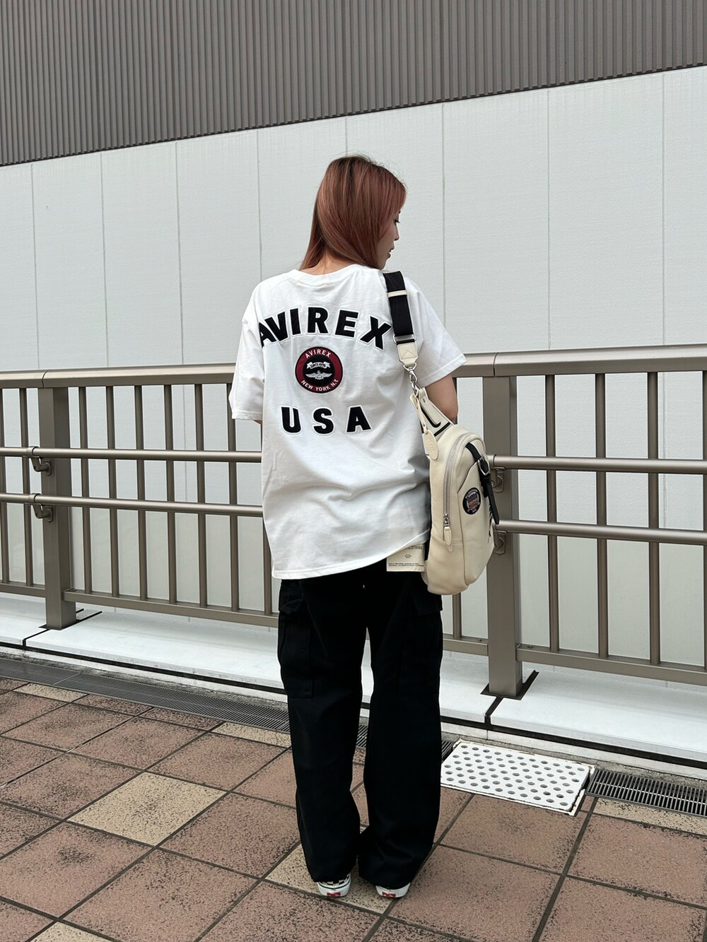 ホワイト系のTシャツ/カットソー、ブラック系のカーゴパンツ、ホワイト系のショルダーバッグを着用したレディースの夏コーディネートの2枚目の写真