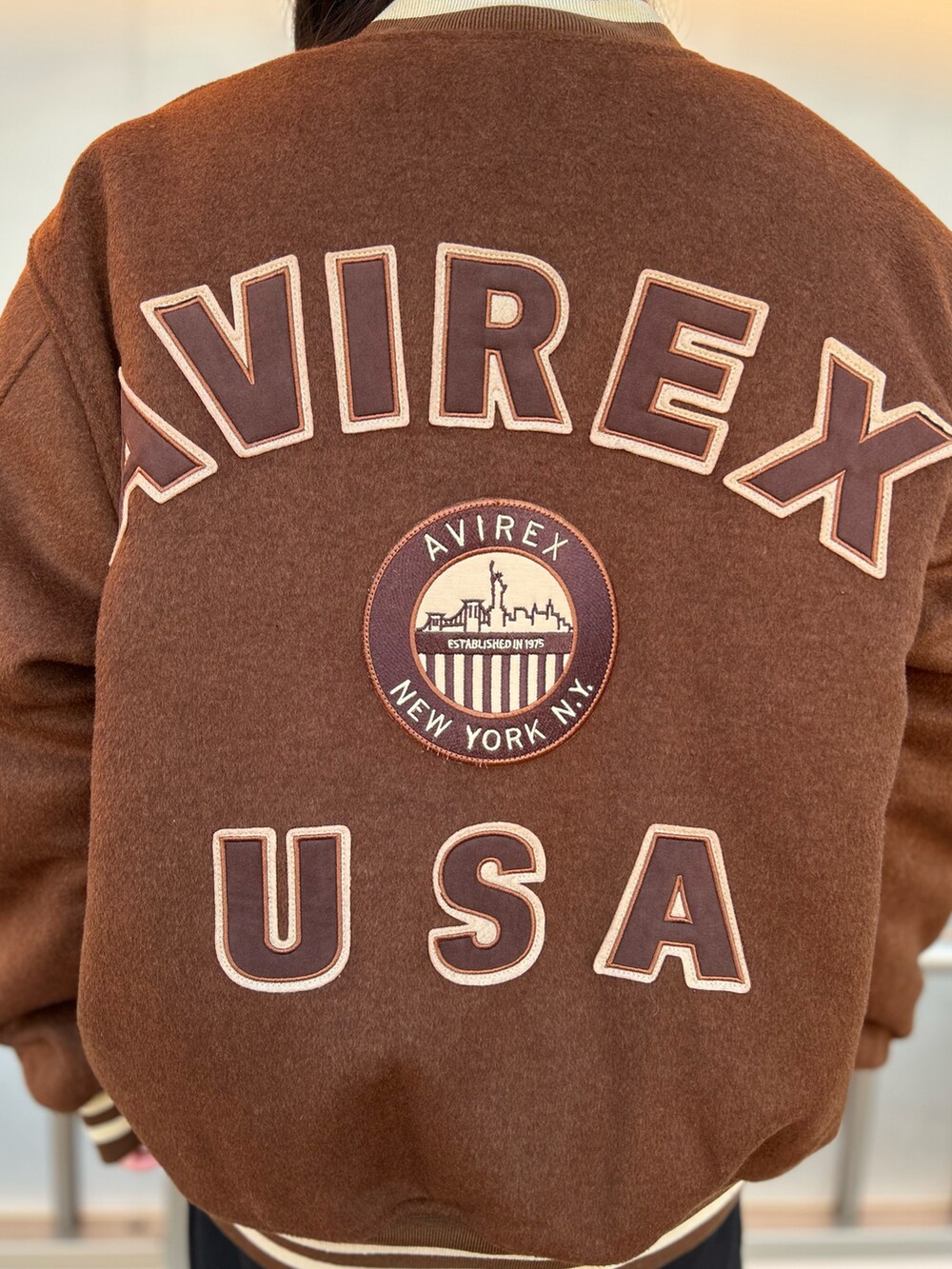 ブラック系のスウェット、ブラック系のスウェットパンツ、ブラウン系のスタジャンを着用したレディースの冬コーディネートの3枚目の写真