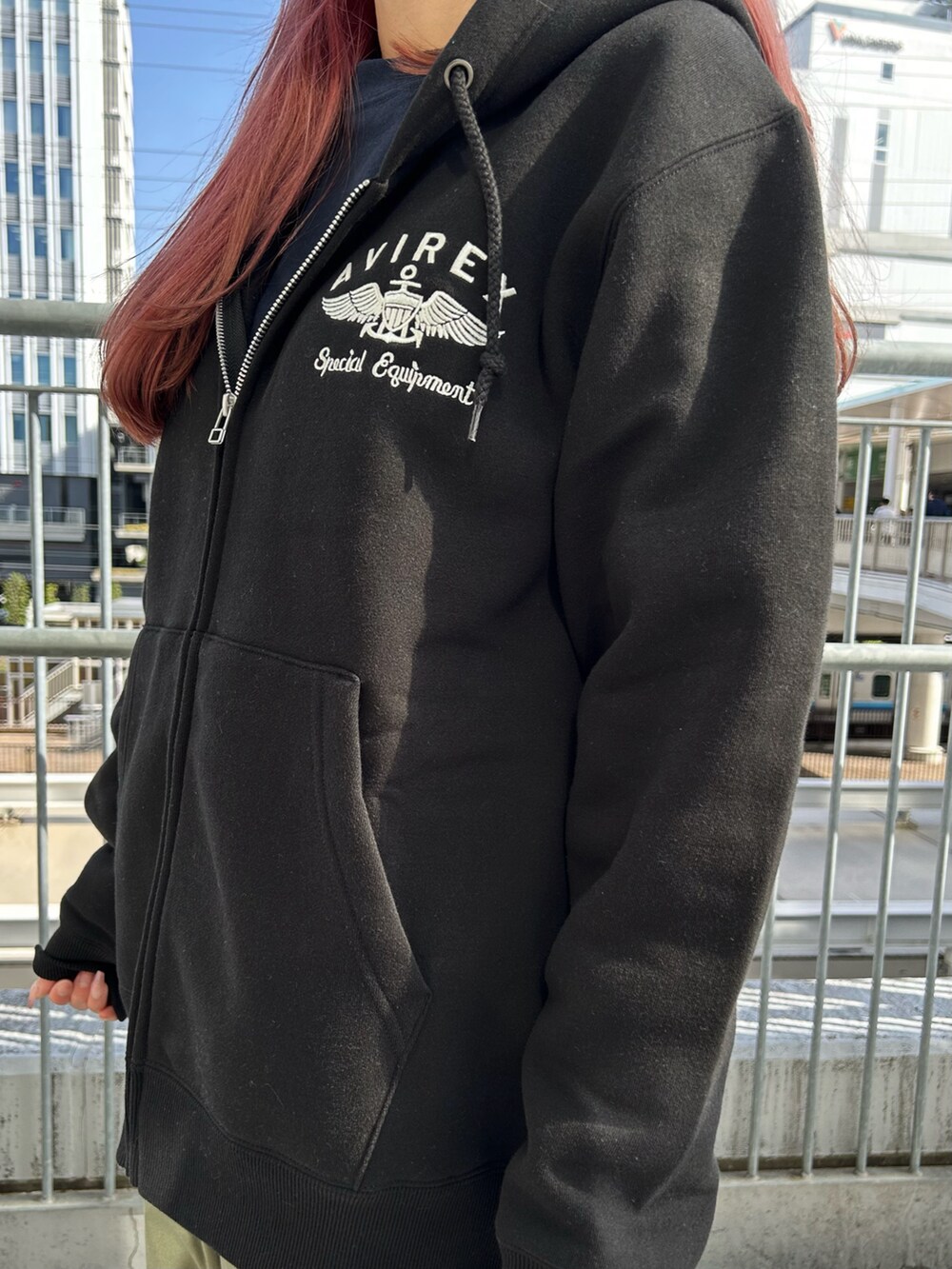 ブラック系のパーカー、ブラック系のバックパック/リュック、ブラック系のキャップを着用したレディースの春コーディネートの4枚目の写真