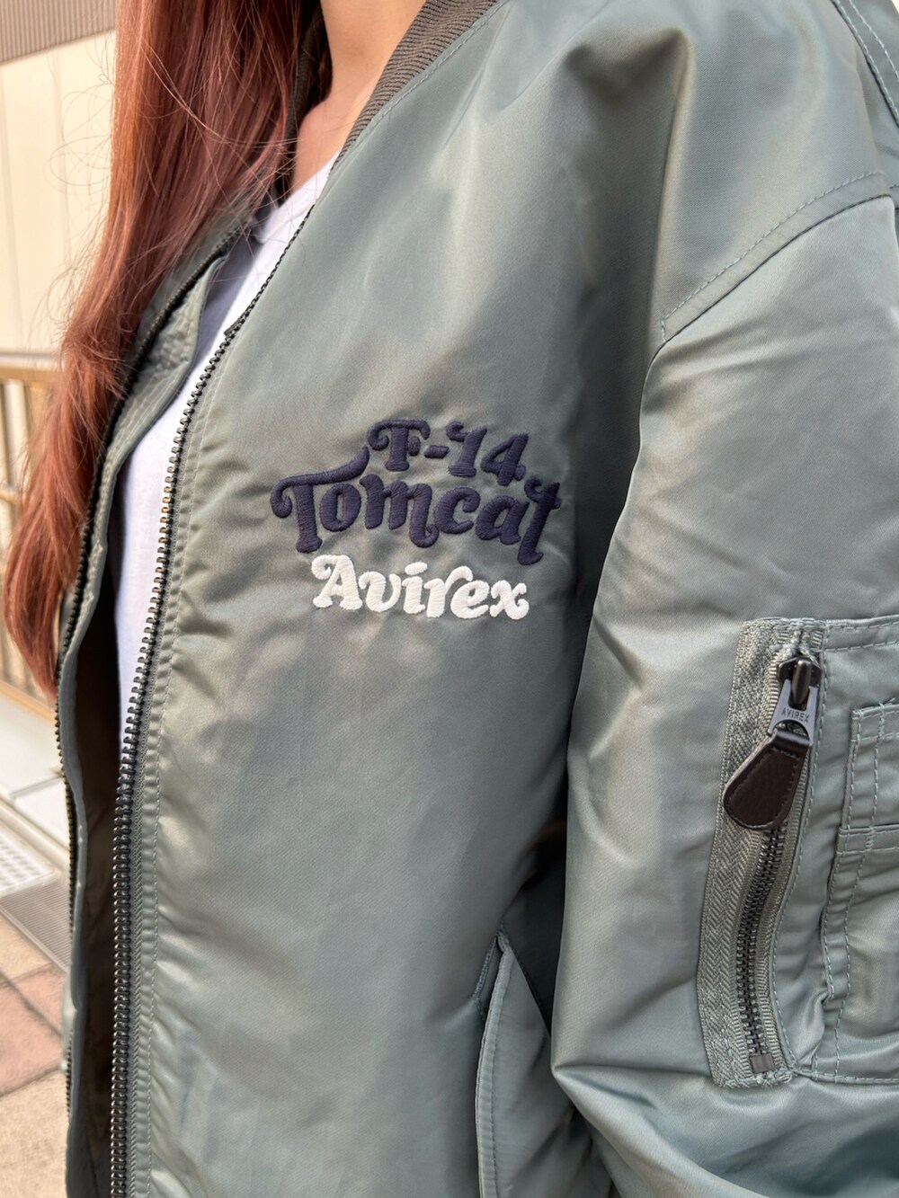 ホワイト系のTシャツ/カットソー、グリーン系のMA-1、ブラック系のキャップを着用したレディースの秋コーディネートの3枚目の写真