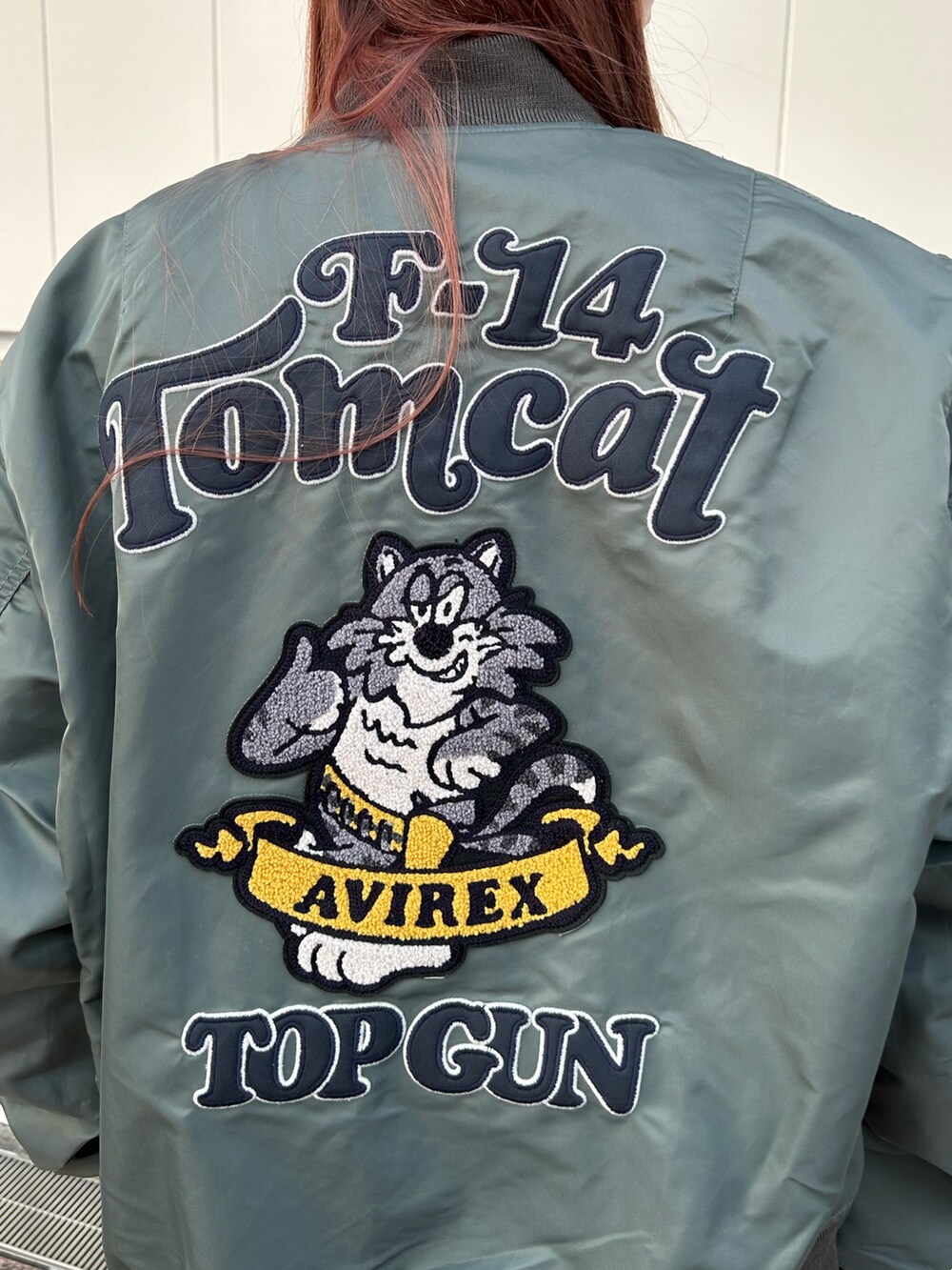 ホワイト系のTシャツ/カットソー、グリーン系のMA-1、ブラック系のキャップを着用したレディースの秋コーディネートの4枚目の写真