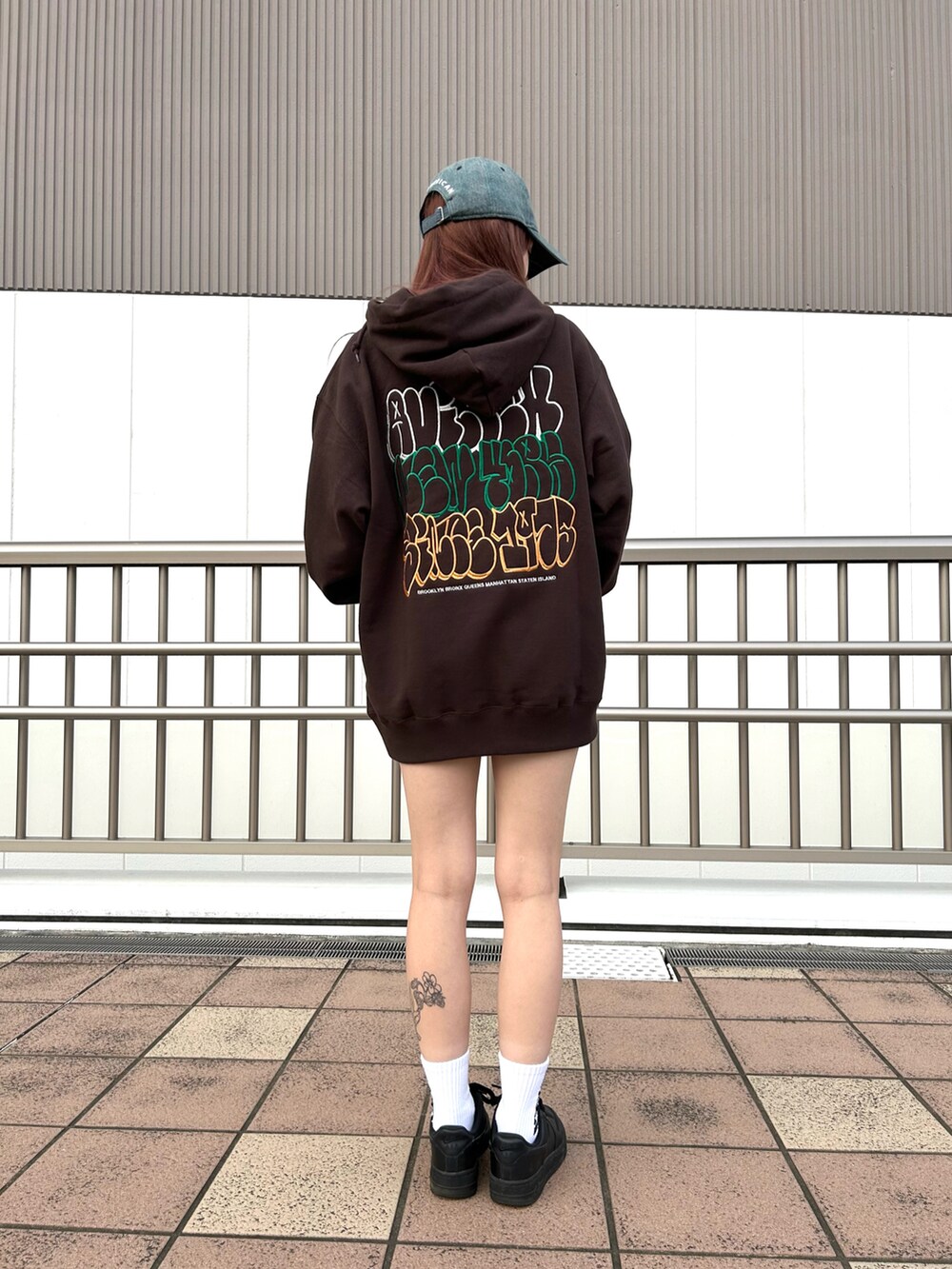 ブラウン系のパーカー、ブルー系のキャップ、ホワイト系のソックス/靴下を着用したレディースの夏コーディネートの2枚目の写真