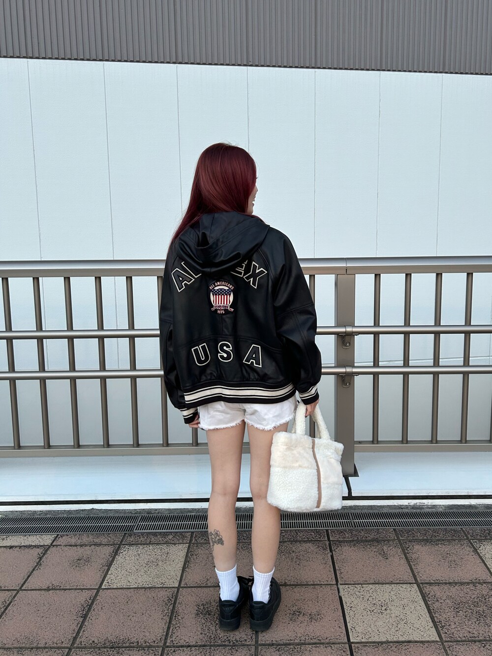 ホワイト系のTシャツ/カットソー、ホワイト系のトートバッグ、ブラック系のブルゾンを着用したレディースの秋コーディネートの2枚目の写真