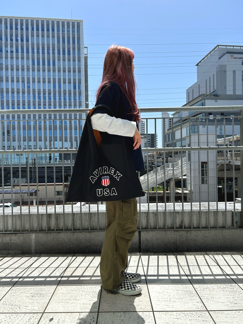 ブルー系のTシャツ/カットソー、グリーン系のカーゴパンツ、ブラック系のトートバッグを着用したレディースの春コーディネートの2枚目の写真