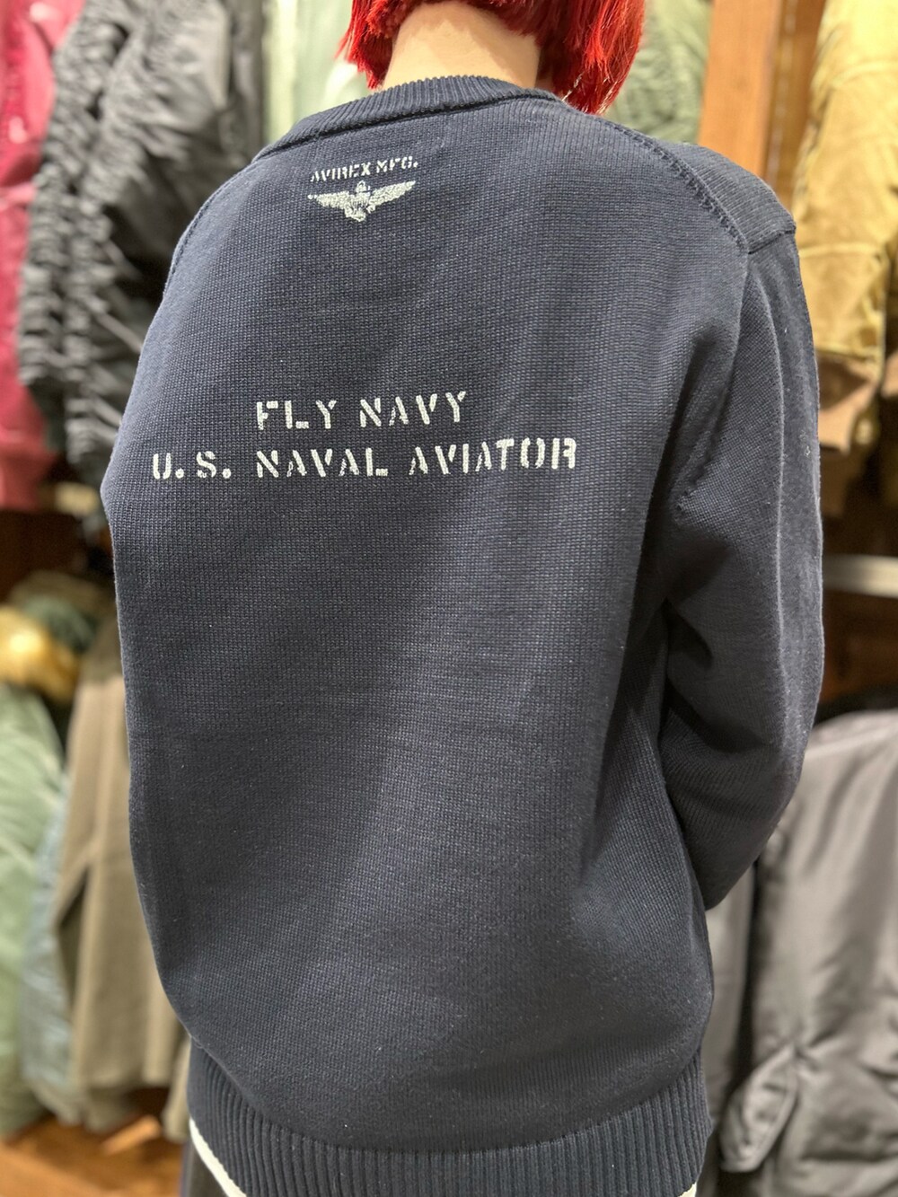 ブルー系のニット/セーター、グリーン系のボストンバッグ、ホワイト系のニットキャップ/ビーニーを着用したレディースの冬コーディネートの4枚目の写真