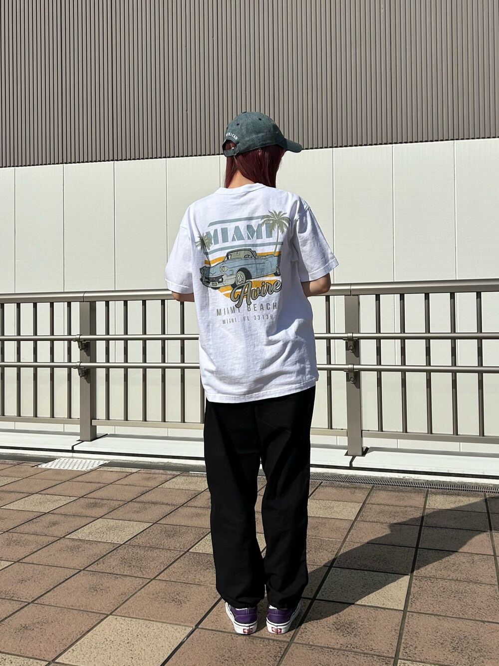 ブラック系のパンツ、ホワイト系のトップス、その他のキャップを着用したレディースの春コーディネートの2枚目の写真