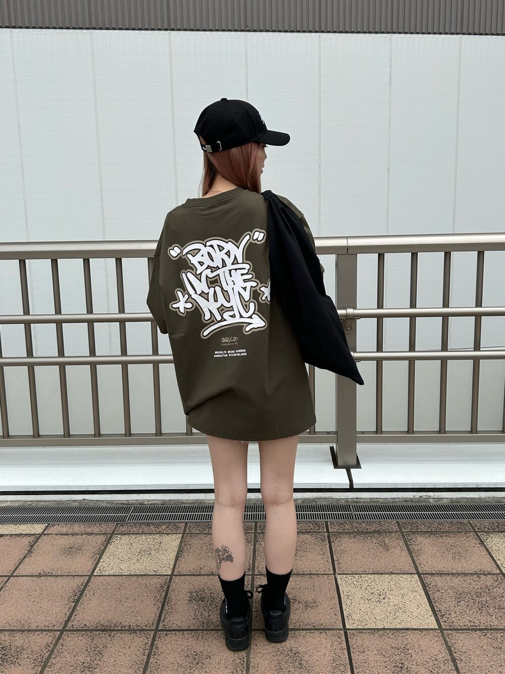 グリーン系のTシャツ/カットソー、ブラック系のトートバッグ、ブラック系のキャップを着用したレディースの夏コーディネートの2枚目の写真