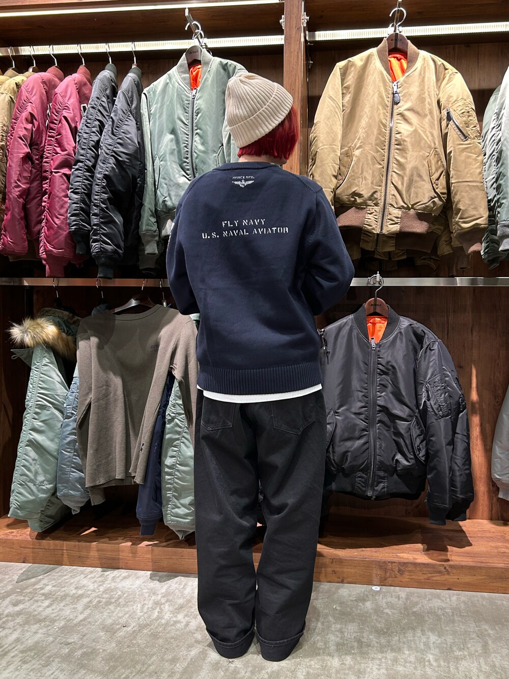 ブルー系のニット/セーター、グリーン系のボストンバッグ、ホワイト系のニットキャップ/ビーニーを着用したレディースの冬コーディネートの2枚目の写真