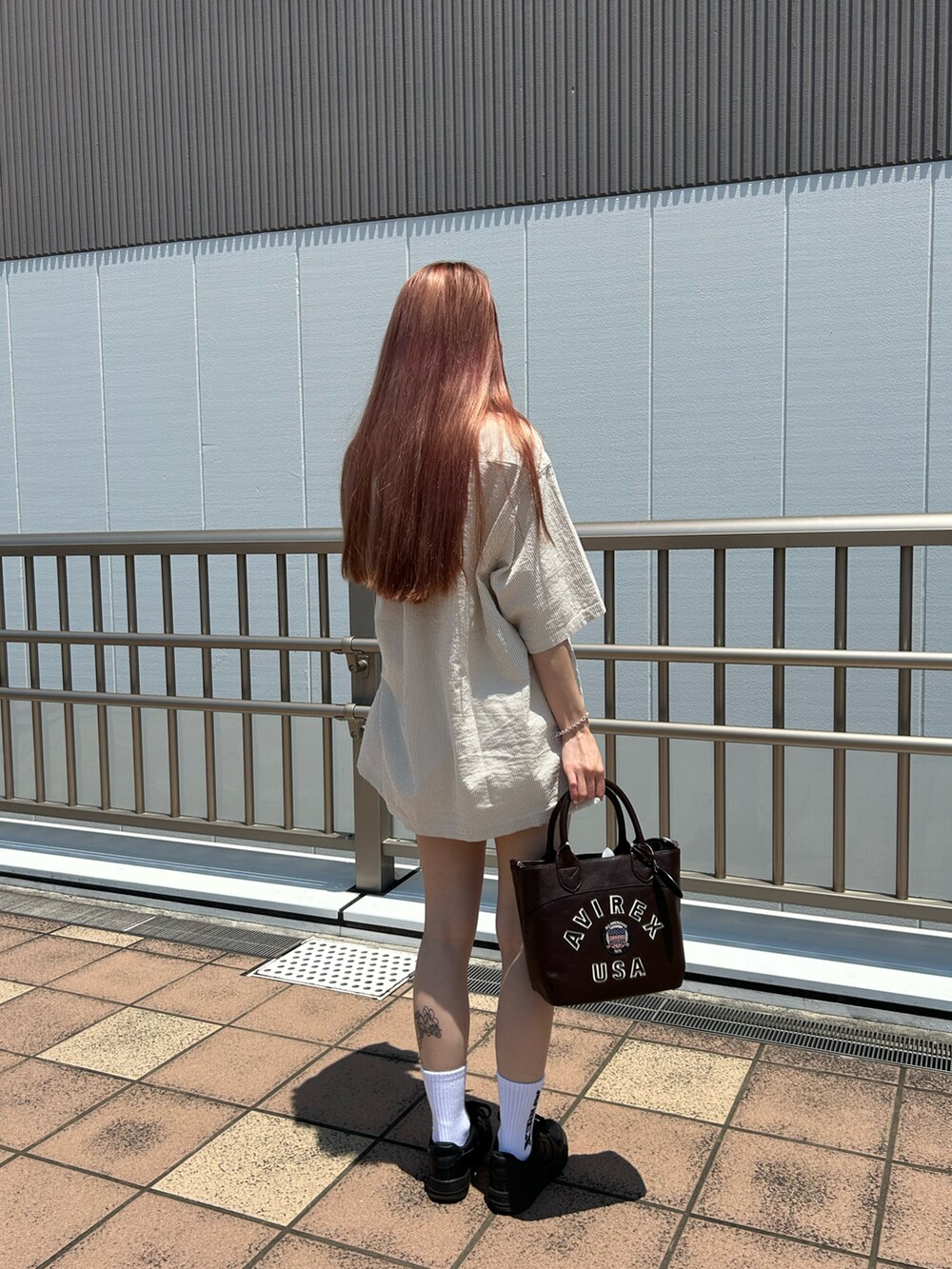 グレー系のシャツ/ブラウス、ブラウン系のトートバッグ、ホワイト系のソックス/靴下を着用したレディースの夏コーディネートの2枚目の写真