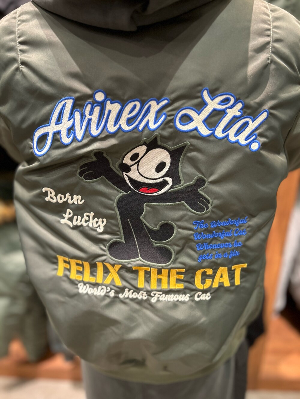 グレー系のパーカー、グレー系のスカート、グリーン系のMA-1を着用したレディースの冬コーディネートの3枚目の写真