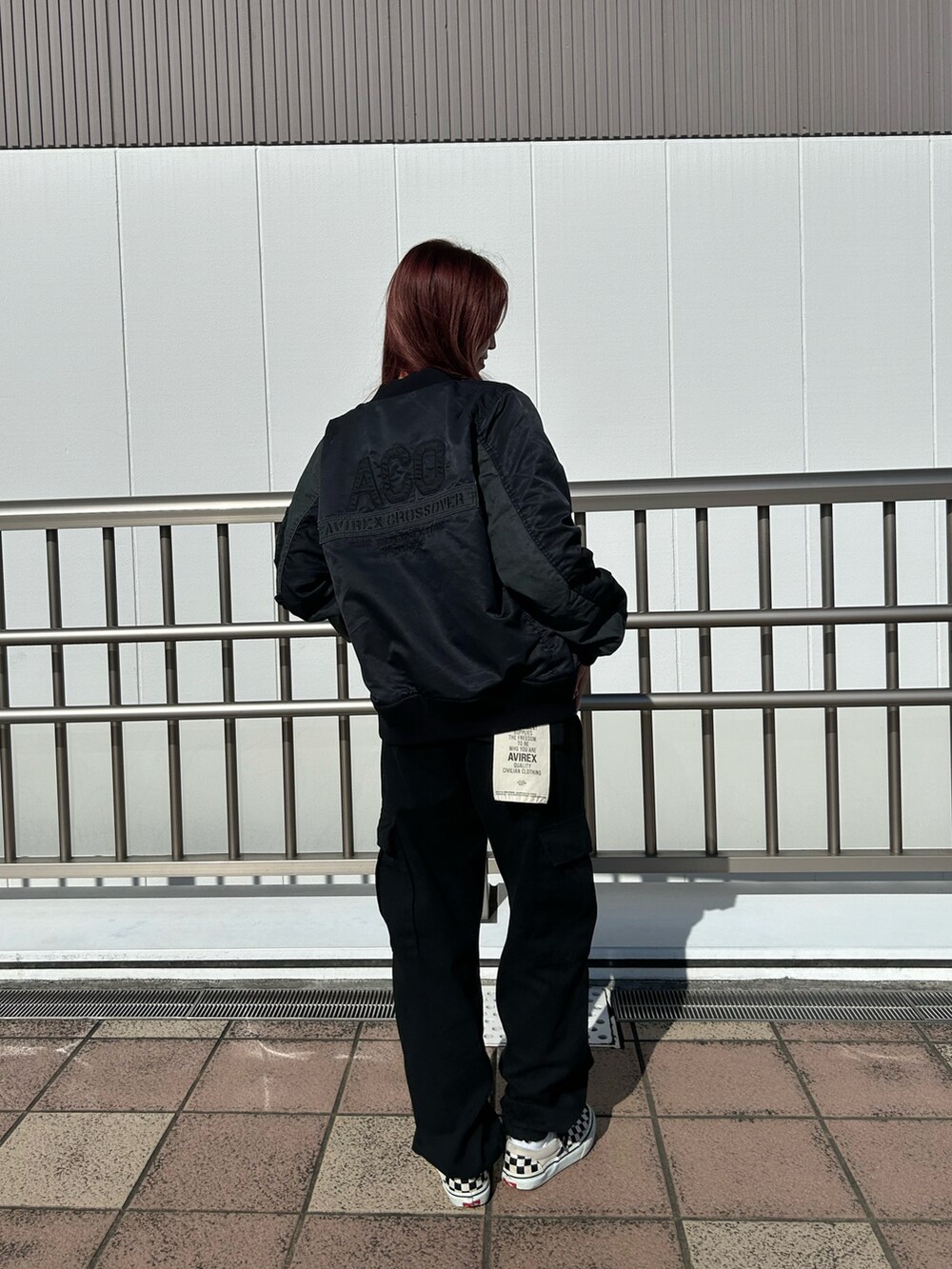 グリーン系のTシャツ/カットソー、ブラック系のカーゴパンツ、ブラック系のMA-1を着用したレディースの秋コーディネートの2枚目の写真