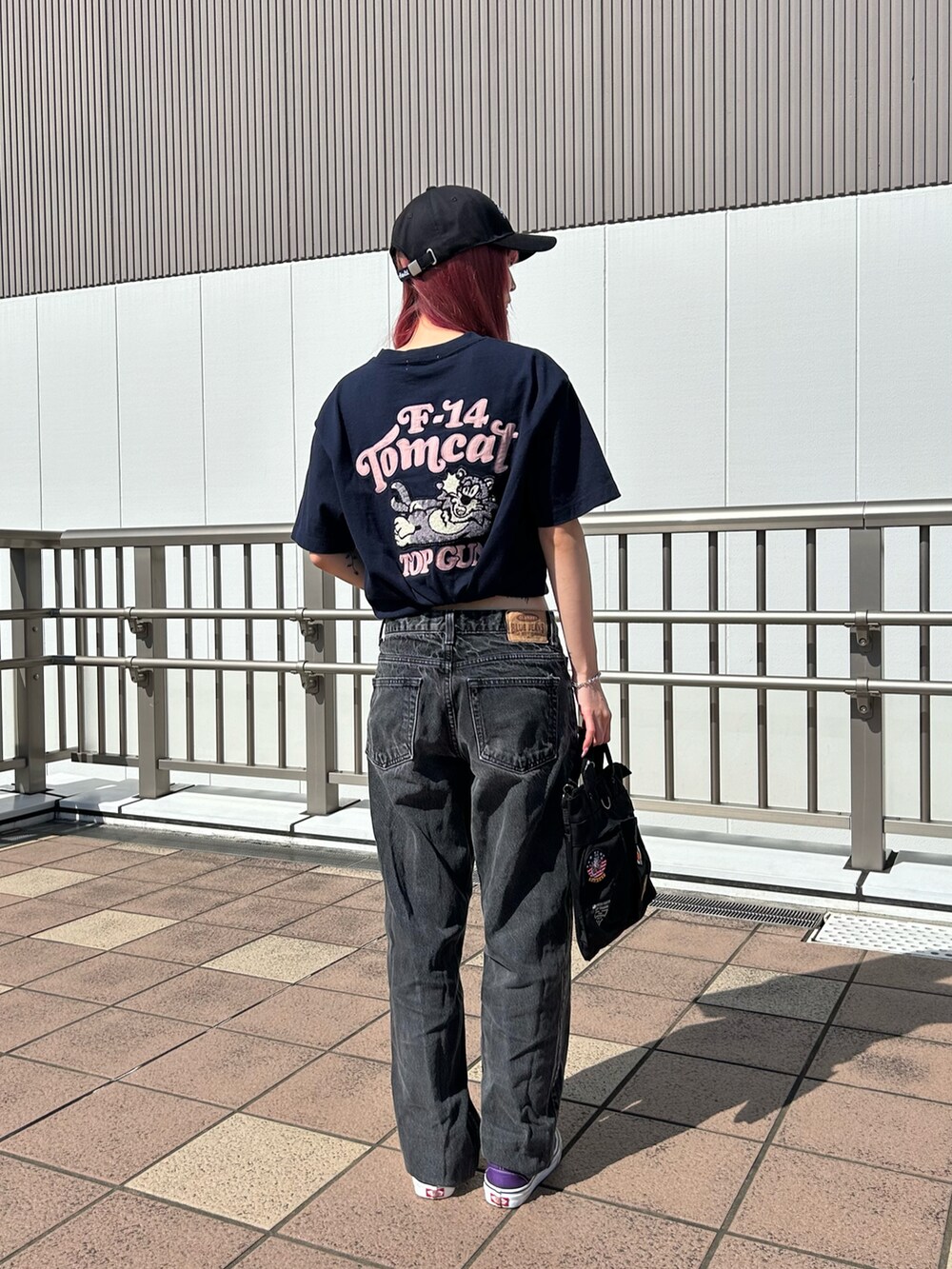 ブルー系のTシャツ/カットソー、ブラック系のショルダーバッグ、ブラック系のキャップを着用したレディースの春コーディネートの2枚目の写真