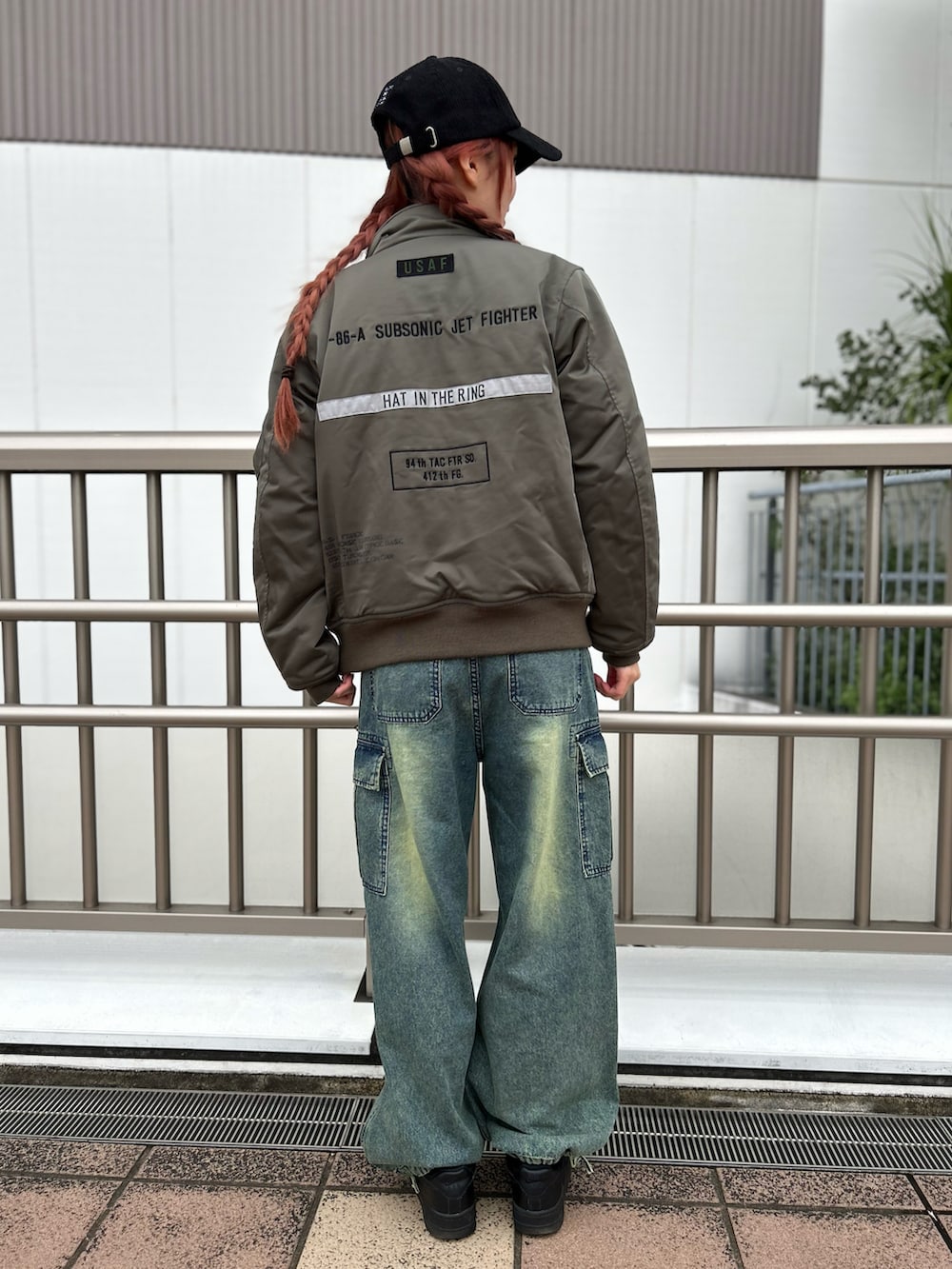 グリーン系のMA-1、ホワイト系のTシャツ/カットソー、ブルー系のデニムパンツを着用したレディースの秋コーディネートの2枚目の写真
