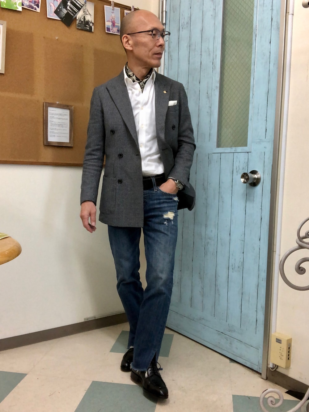 ホワイト系のパーカー、ブルー系のデニムパンツ、ベージュ系のトートバッグを着用したメンズの春コーディネートの2枚目の写真