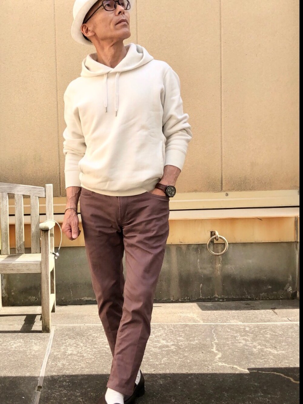ホワイト系のパーカー、ブルー系のデニムパンツ、ベージュ系のトートバッグを着用したメンズの春コーディネートの3枚目の写真