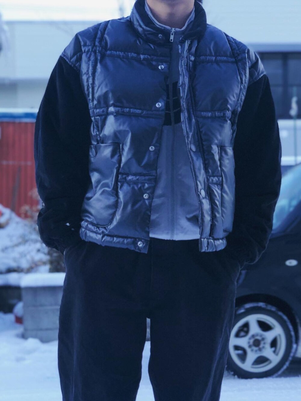 ブラック系のダウンベスト、シルバー系のジャージ、ブラック系のデニムパンツを着用したメンズの冬コーディネートの3枚目の写真