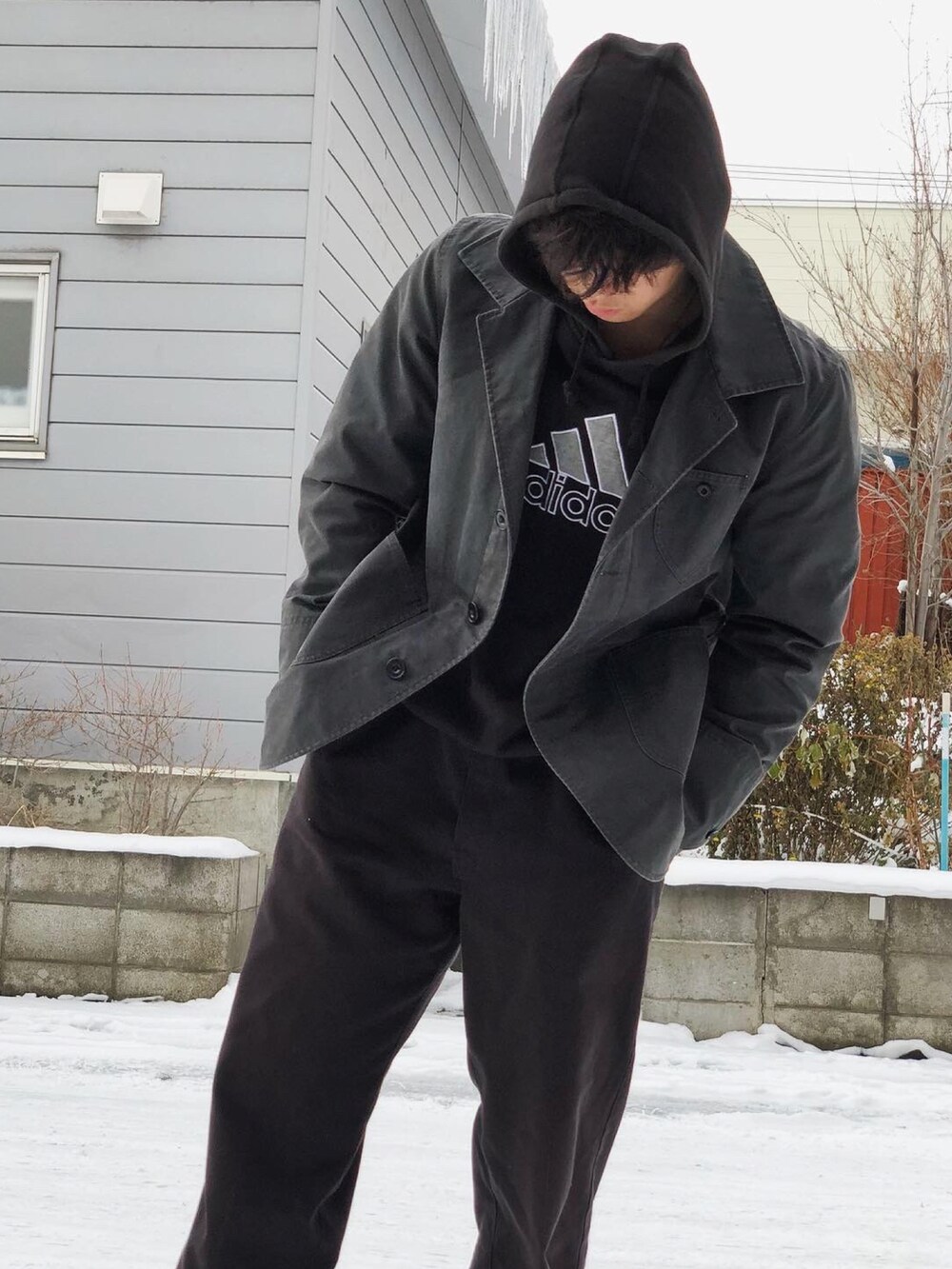 ブラック系のパンツ、ブラック系のブーツ、ブラック系のパーカーを着用したメンズの冬コーディネートの5枚目の写真