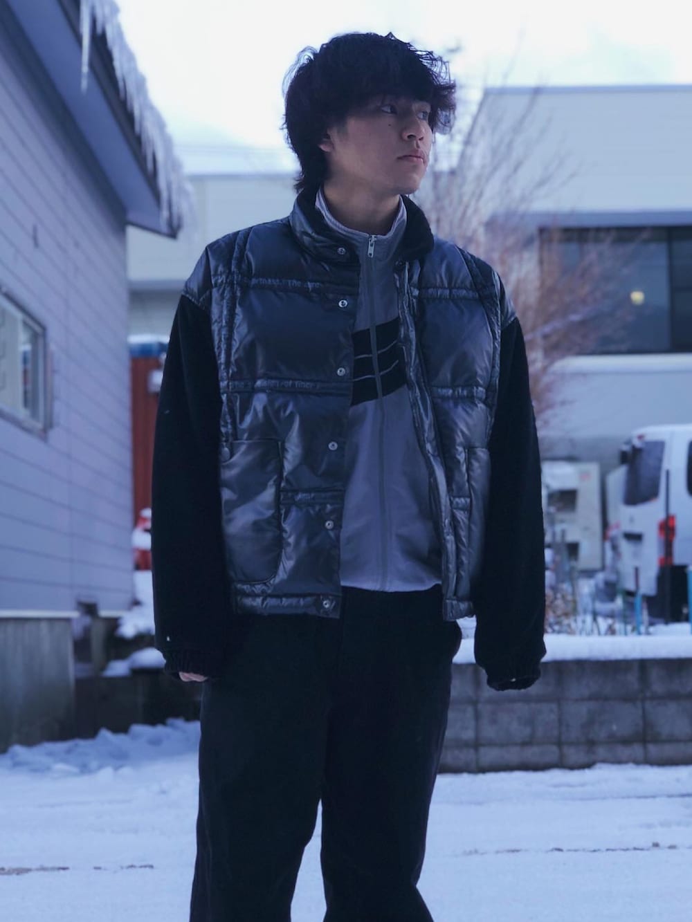 ブラック系のダウンベスト、シルバー系のジャージ、ブラック系のデニムパンツを着用したメンズの冬コーディネートの4枚目の写真