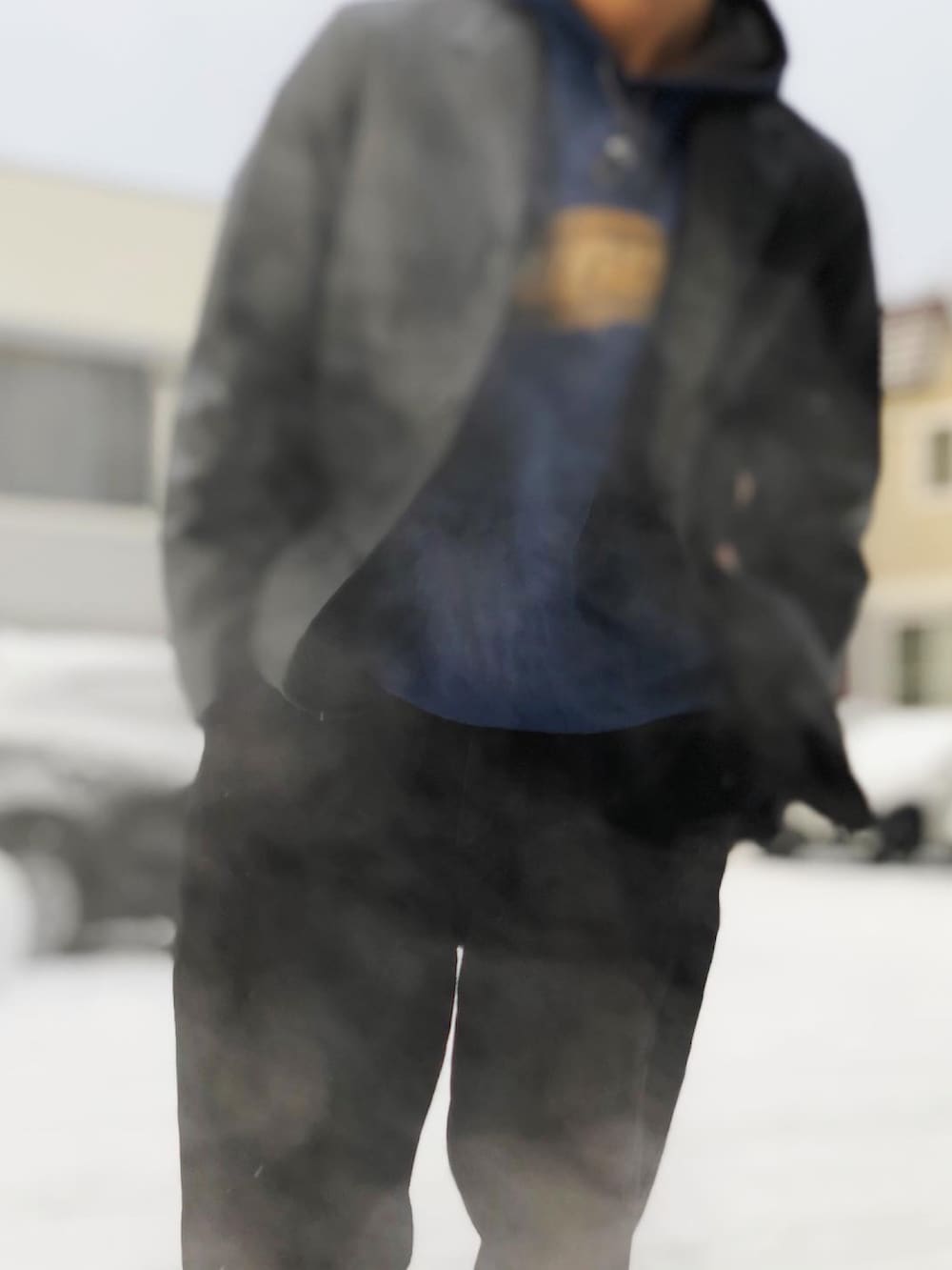 ブラック系のテーラードジャケット、ブルー系のパーカー、ブラック系のデニムパンツを着用したメンズの冬コーディネートの3枚目の写真