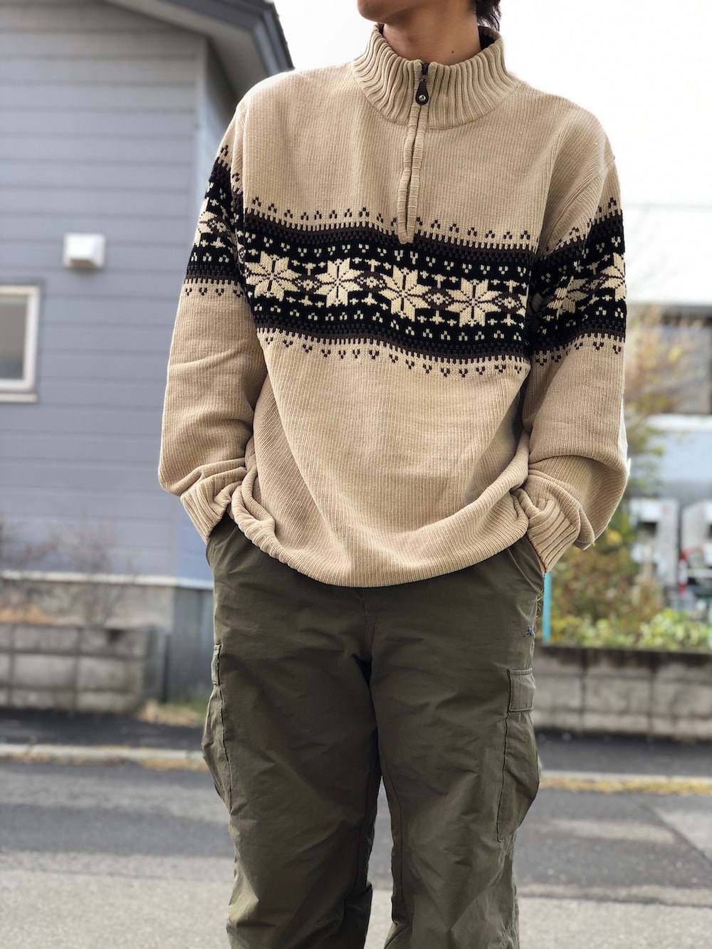 グリーン系のカーゴパンツ、ブラウン系のブーツ、ベージュ系のニット/セーターを着用したメンズの秋コーディネートの3枚目の写真