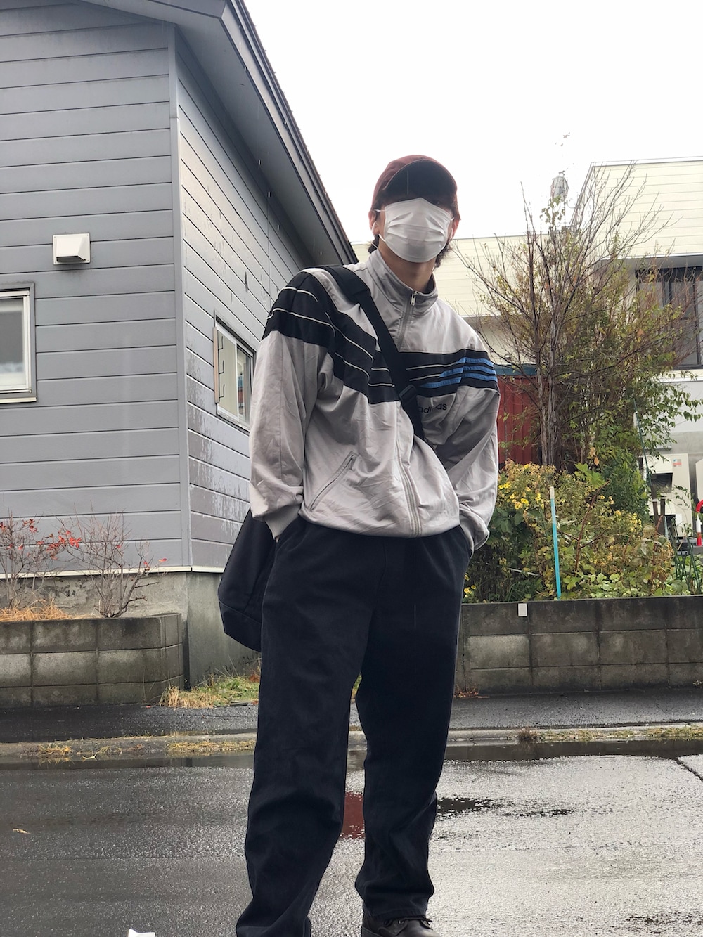 シルバー系のジャージ、ブラック系のショルダーバッグ、ブラック系のデニムパンツを着用したメンズの秋コーディネートの2枚目の写真