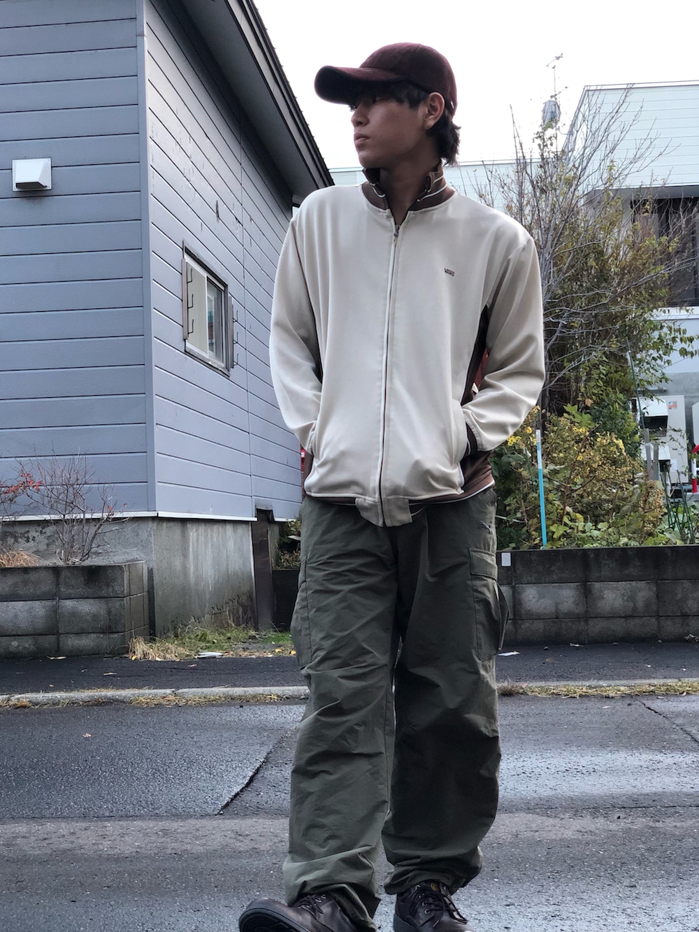 ブラウン系のジャージ、グリーン系のカーゴパンツ、ブラウン系のブーツを着用したメンズの秋コーディネートの2枚目の写真