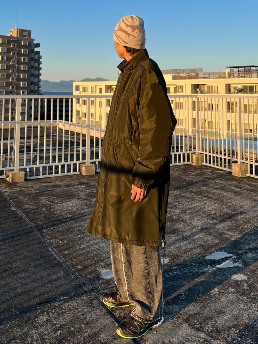 ブラック系のデニムパンツ、ブラック系のスニーカー、グリーン系のダウンジャケット/コートを着用したメンズの冬コーディネートの3枚目の写真