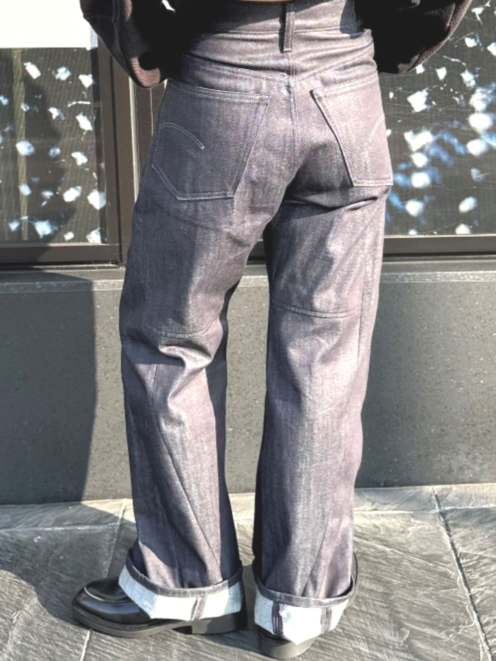 ブラック系のスウェット、ブルー系のデニムパンツを着用したレディースの秋コーディネートの2枚目の写真