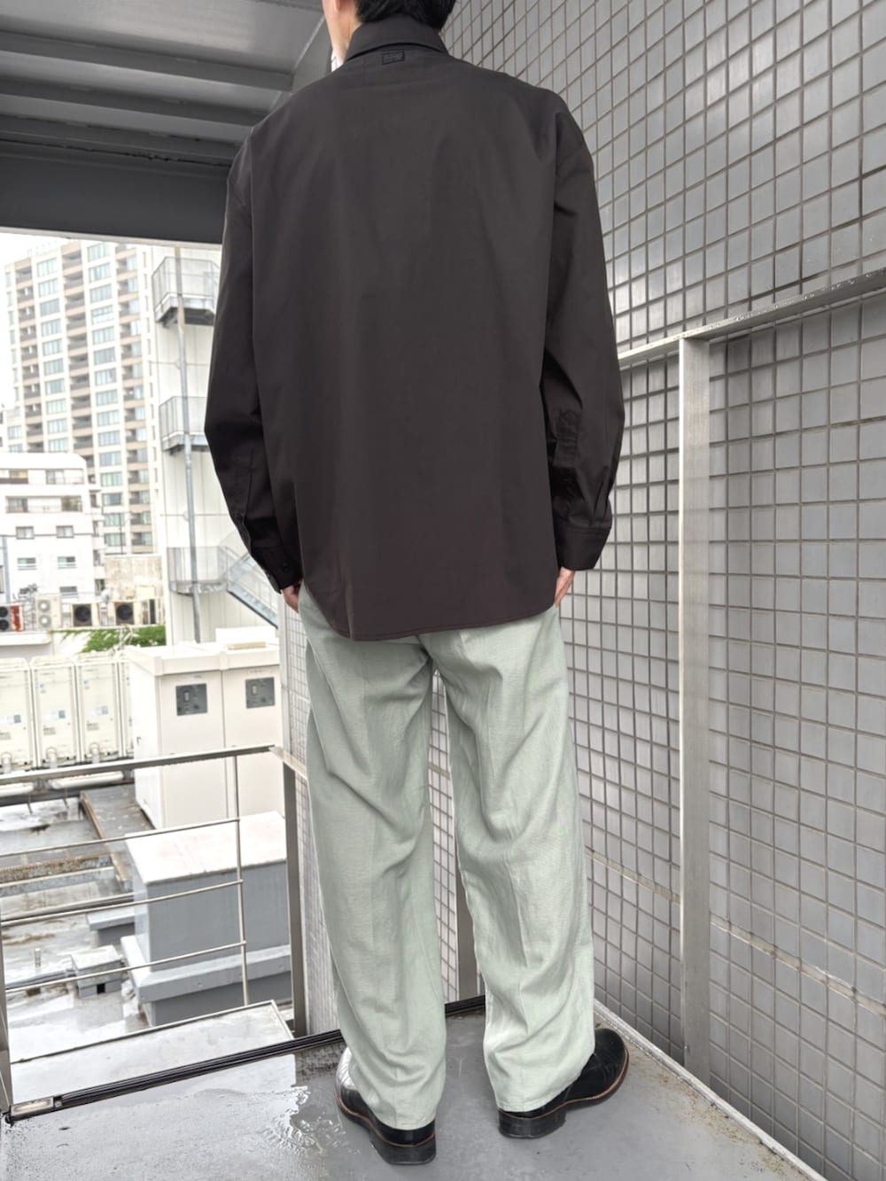 ブラック系のシャツ/ブラウス、グリーン系のスラックスを着用したメンズの春コーディネートの3枚目の写真