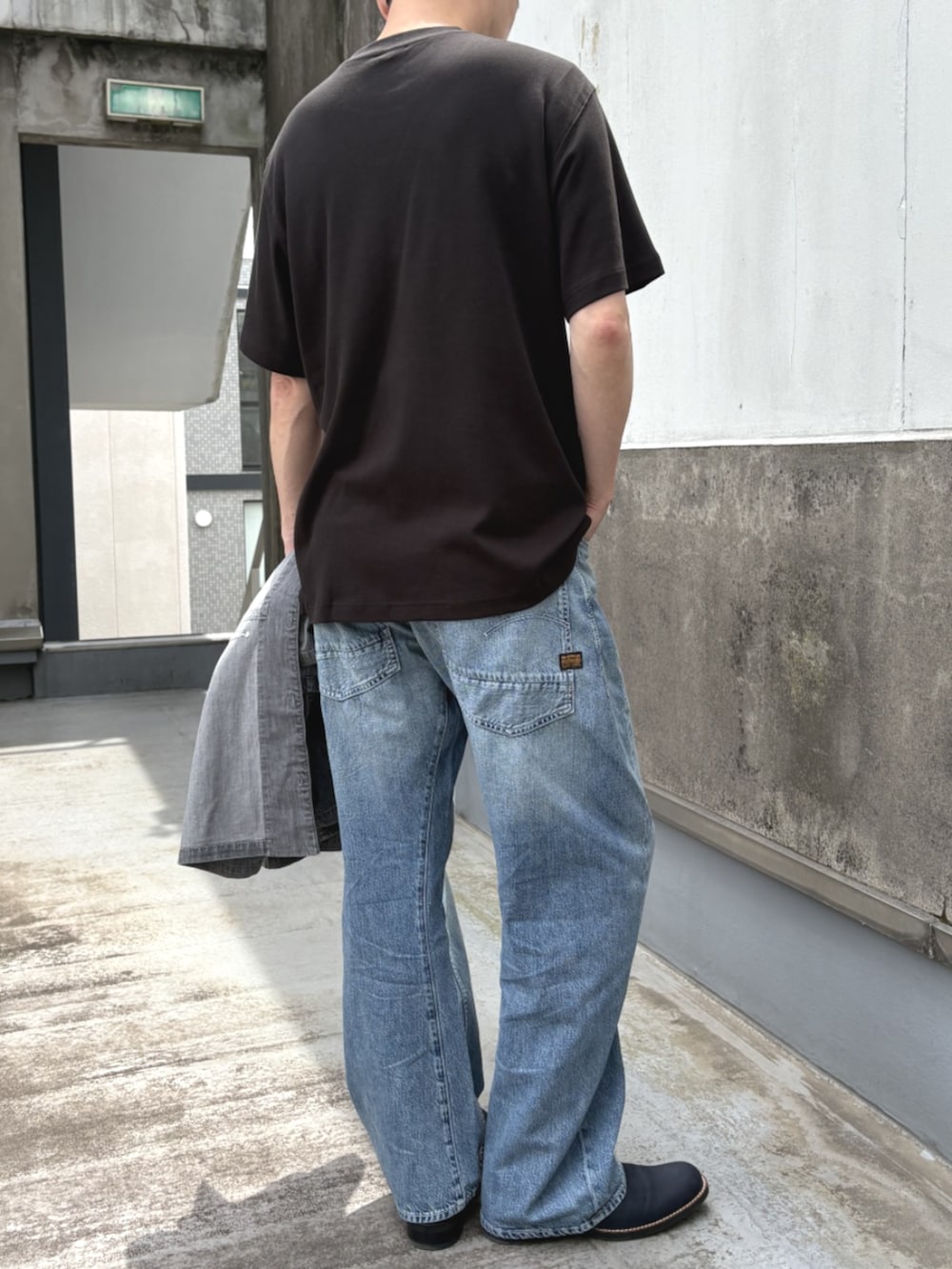 ブラック系のTシャツ/カットソー、ブルー系のデニムパンツを着用したメンズの夏コーディネートの2枚目の写真