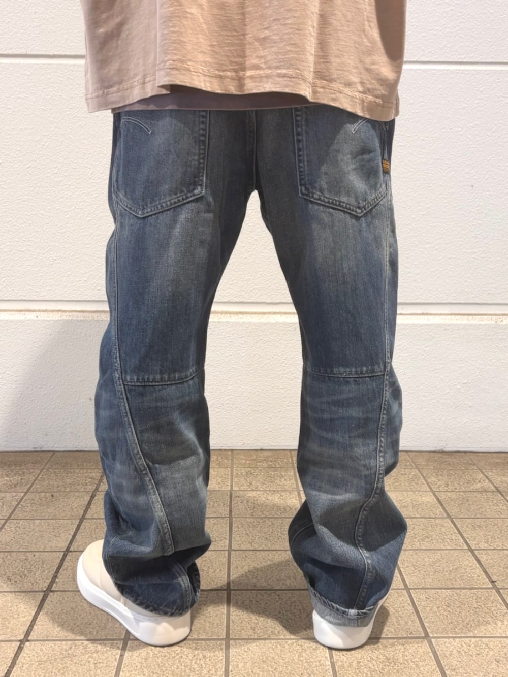 ベージュ系のTシャツ/カットソー、ブルー系のデニムパンツを着用したメンズの秋コーディネートの2枚目の写真