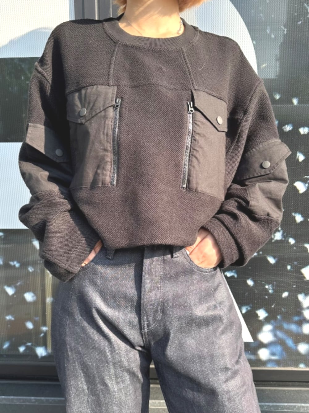 ブラック系のスウェット、ブルー系のデニムパンツを着用したレディースの秋コーディネートの3枚目の写真