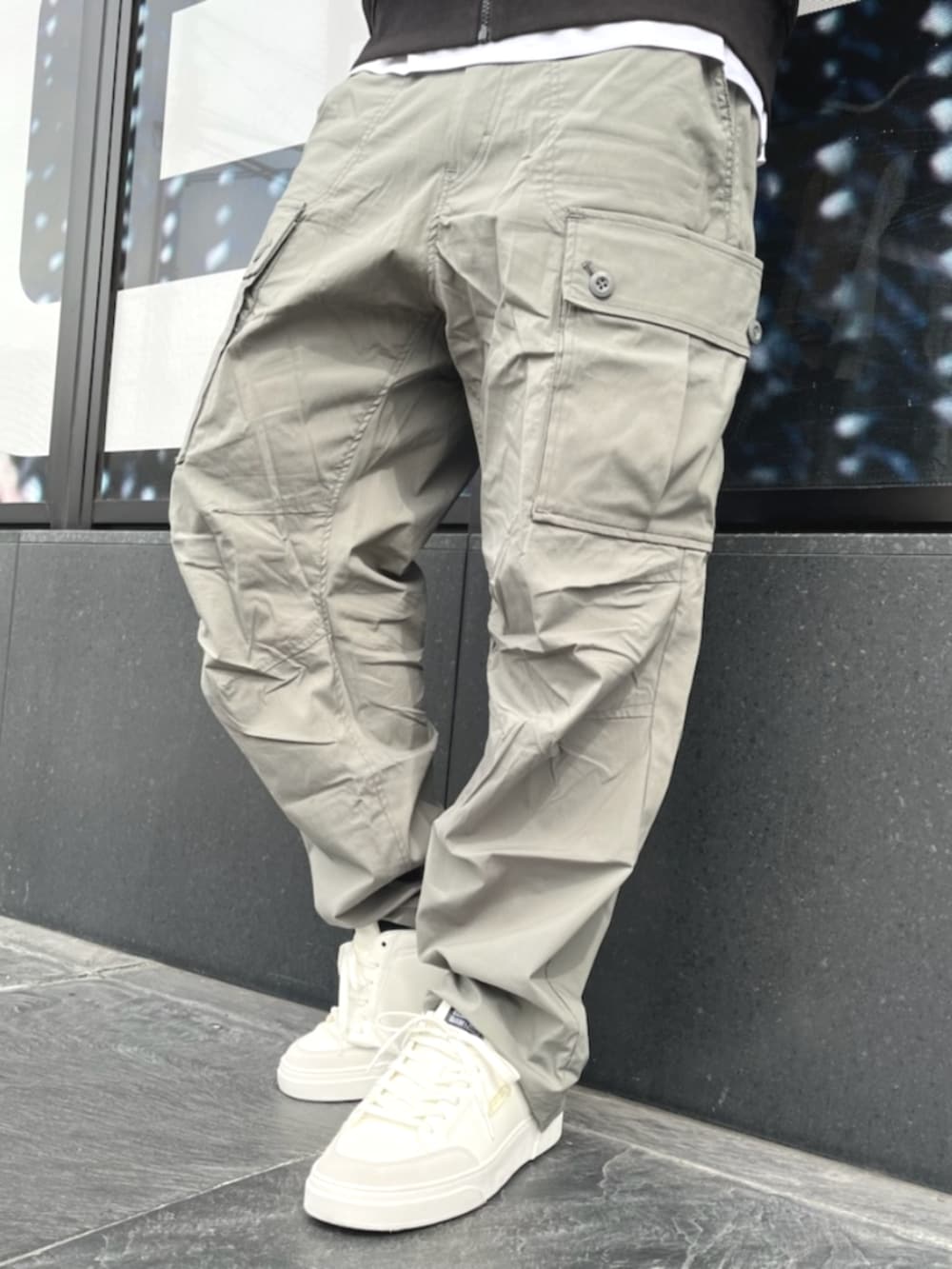 グレー系のカーゴパンツ、ブラック系のジャージ、ホワイト系のTシャツ/カットソーを着用したメンズの夏コーディネートの3枚目の写真