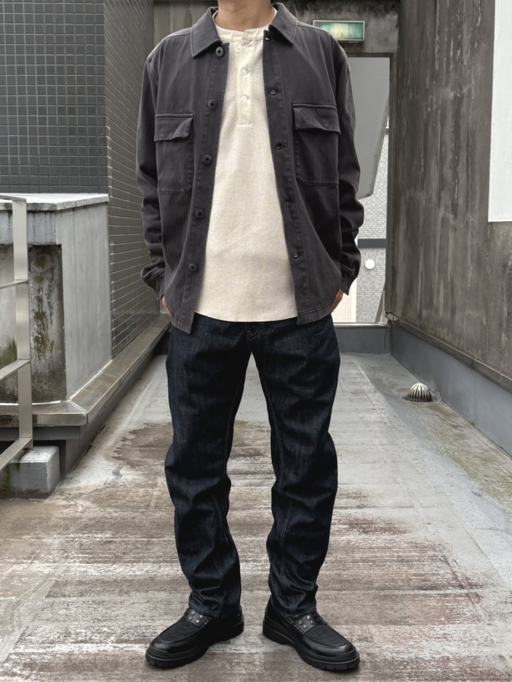 ブラック系のローファー、ホワイト系のTシャツ/カットソー、ブルー系のデニムパンツを着用したメンズの秋コーディネートの2枚目の写真