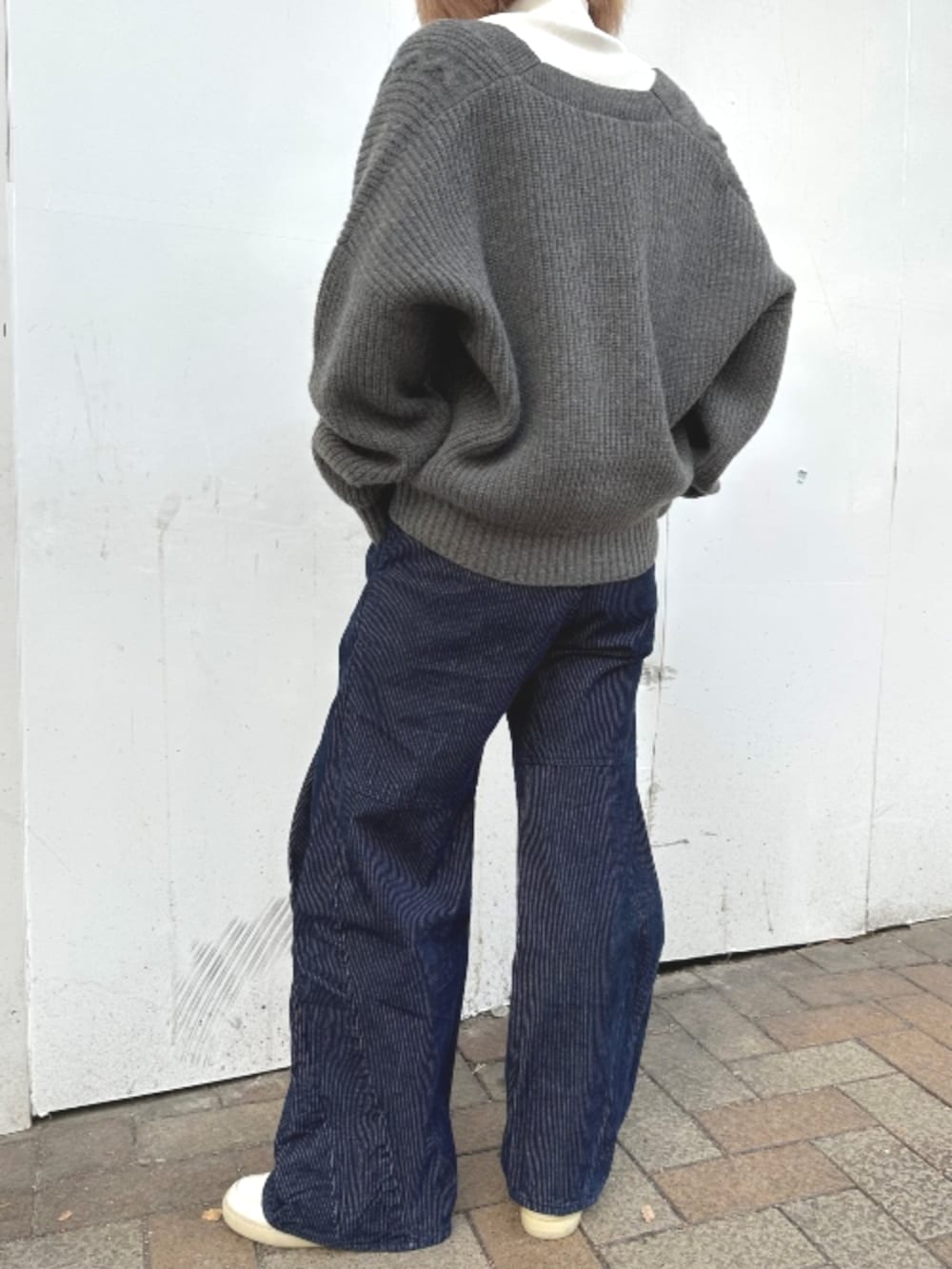 グレー系のカーディガン/ボレロ、ホワイト系のTシャツ/カットソー、ブルー系のデニムパンツを着用したレディースの秋コーディネートの3枚目の写真