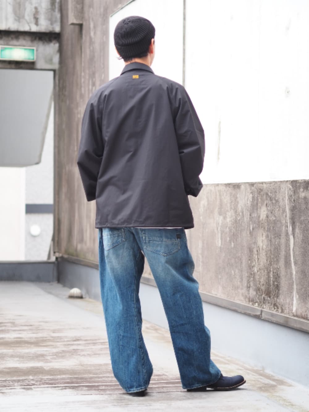 ブラック系のナイロンジャケット、ブルー系のデニムパンツ、ホワイト系のTシャツ/カットソーを着用したメンズの春コーディネートの2枚目の写真