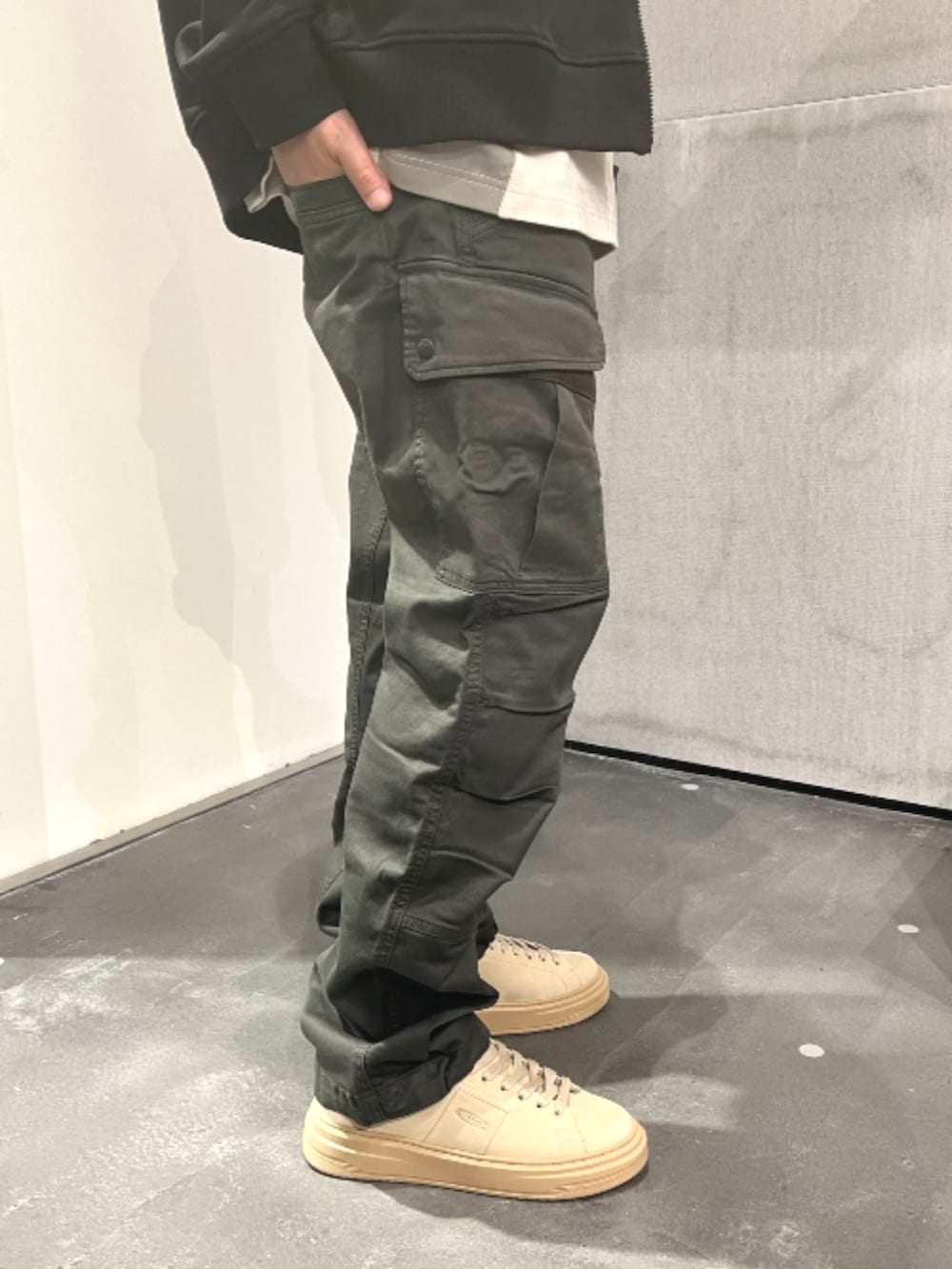 グリーン系のカーゴパンツ、ブラック系のパーカーを着用したメンズの秋コーディネートの5枚目の写真