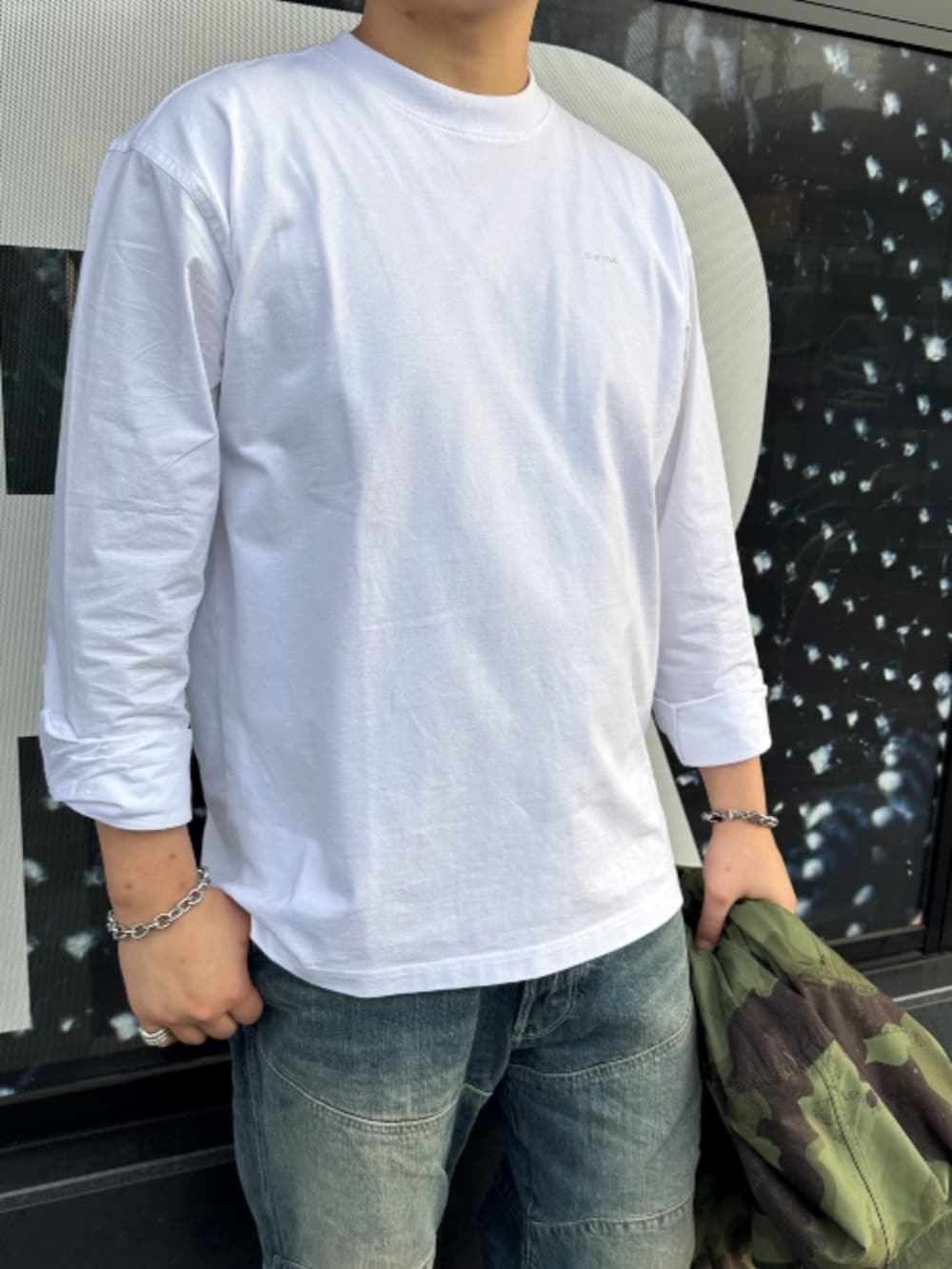 グリーン系のシャツ/ブラウス、ホワイト系のTシャツ/カットソー、ブルー系のデニムパンツを着用したメンズの春コーディネートの3枚目の写真