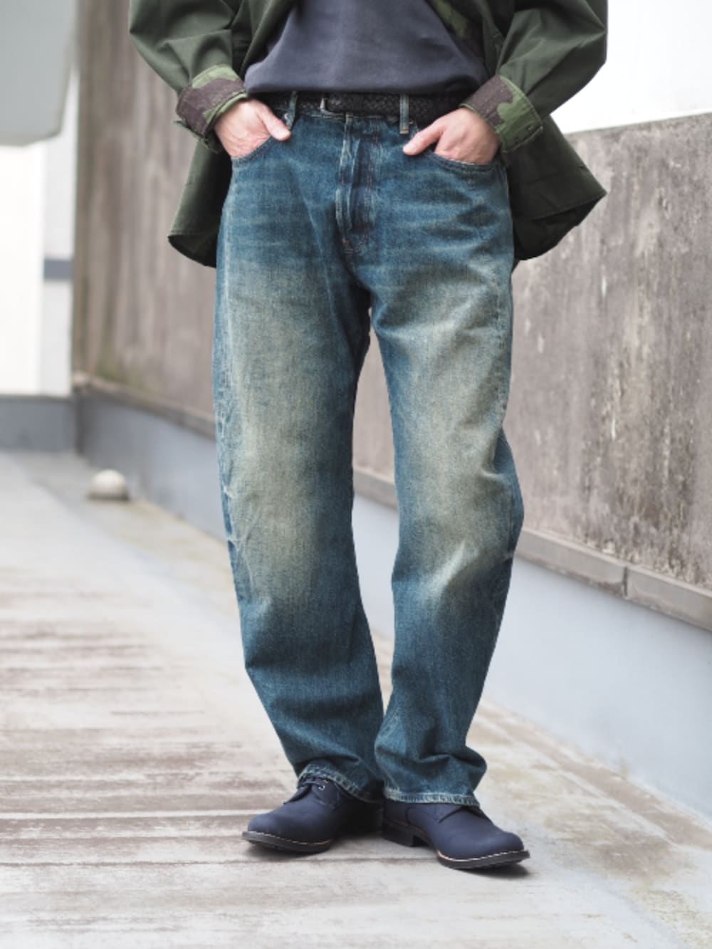 グリーン系のミリタリージャケット、ブルー系のデニムパンツを着用したメンズの春コーディネートの3枚目の写真