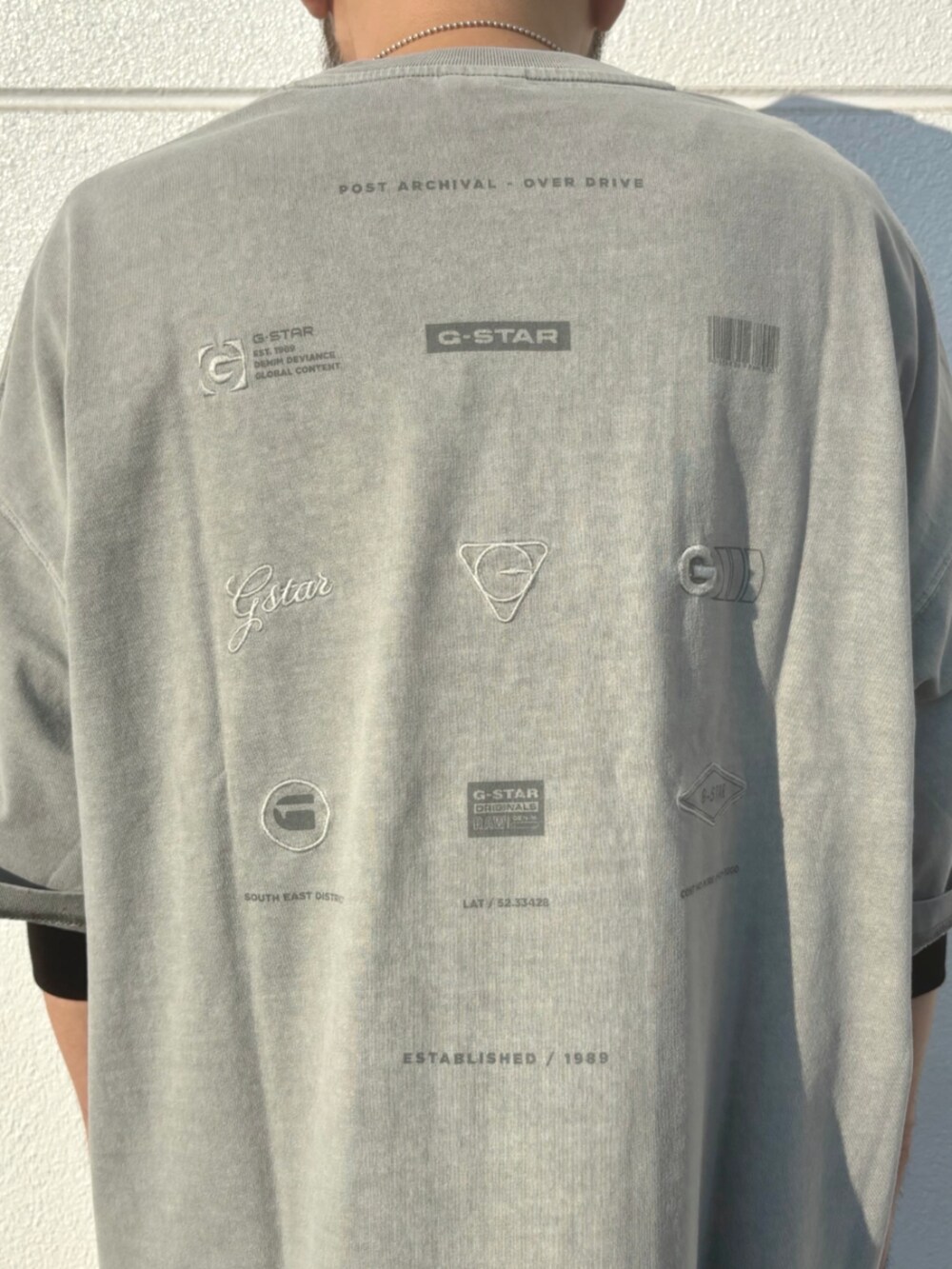 ブラック系のスニーカー、グレー系のTシャツ/カットソー、グレー系のカーゴパンツを着用したメンズの秋コーディネートの2枚目の写真
