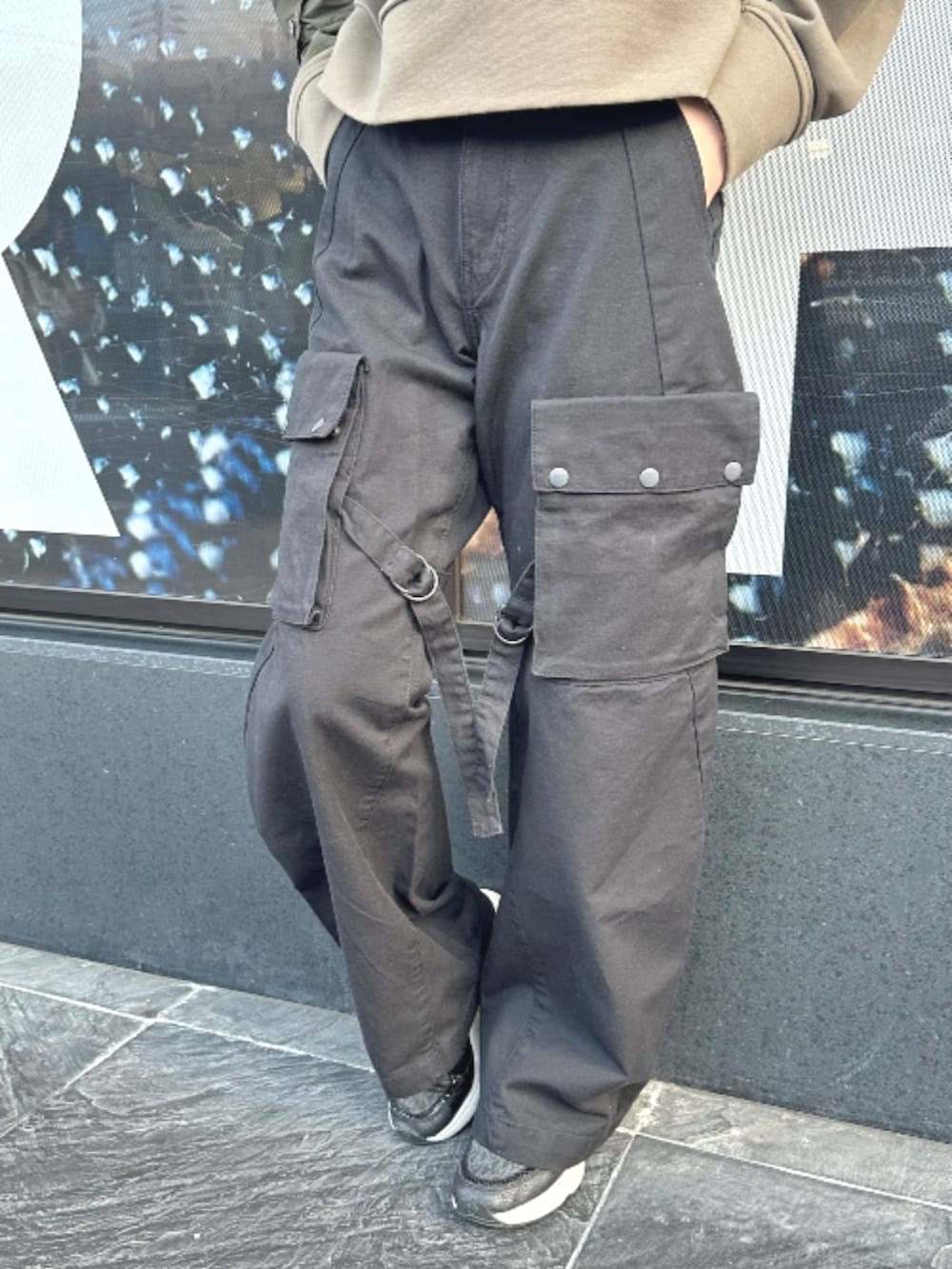 ブラウン系のスウェット、ブラック系のカーゴパンツを着用したレディースの春コーディネートの3枚目の写真