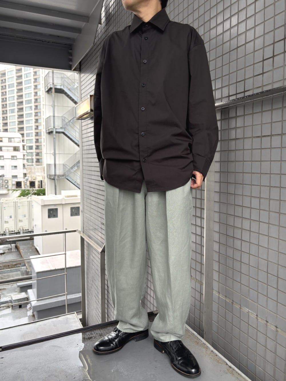 ブラック系のシャツ/ブラウス、グリーン系のスラックスを着用したメンズの春コーディネートの2枚目の写真