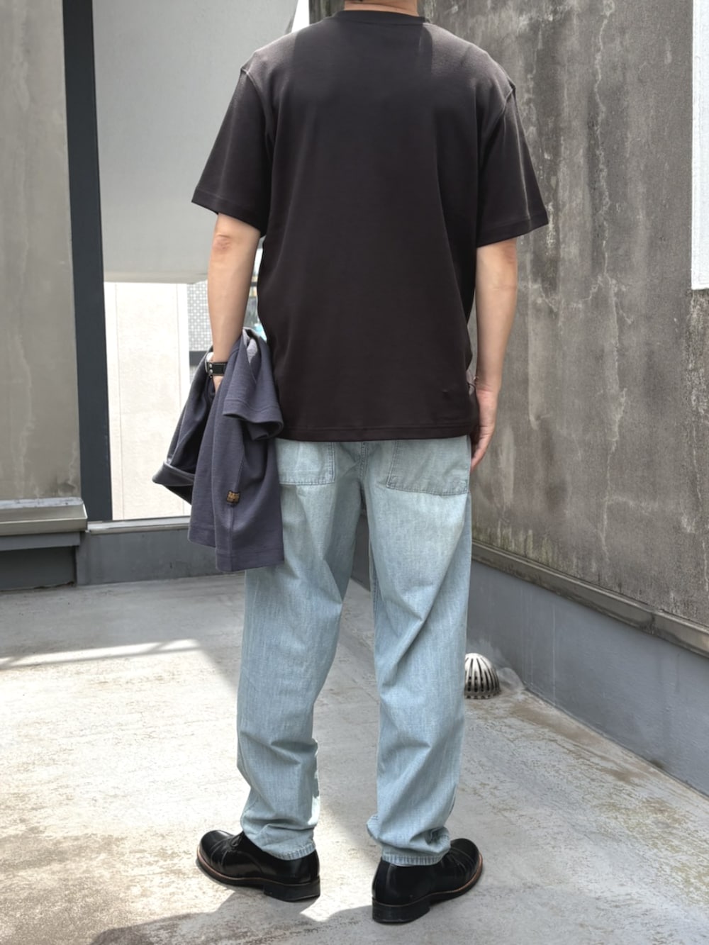 ブルー系のデニムパンツ、ブラック系のTシャツ/カットソーを着用したメンズの夏コーディネートの2枚目の写真