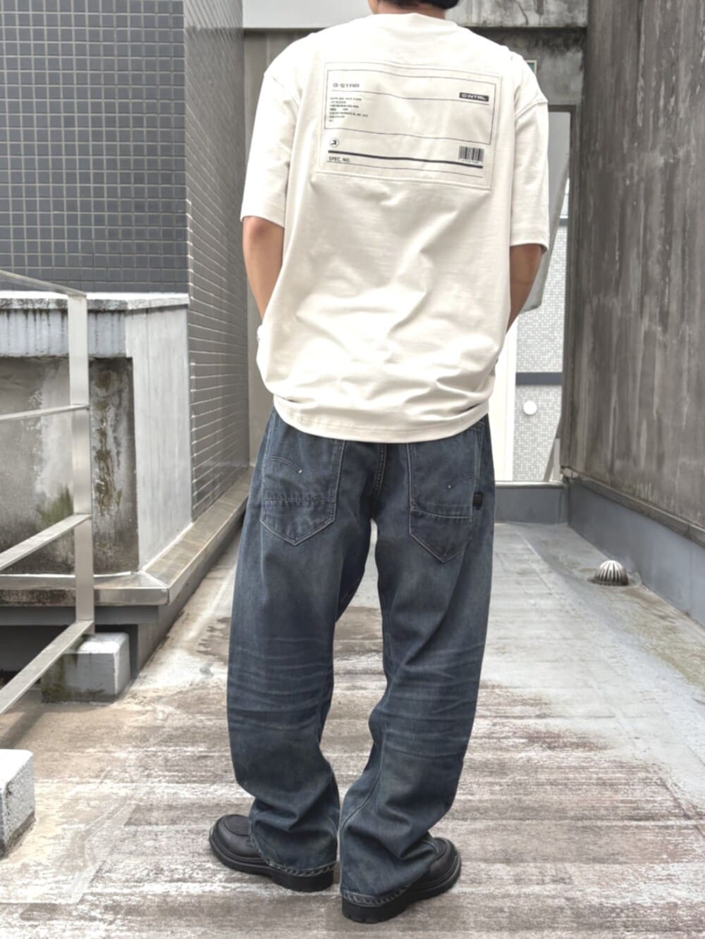 ブラック系のローファー、ブルー系のデニムパンツ、ホワイト系のTシャツ/カットソーを着用したメンズの秋コーディネートの2枚目の写真