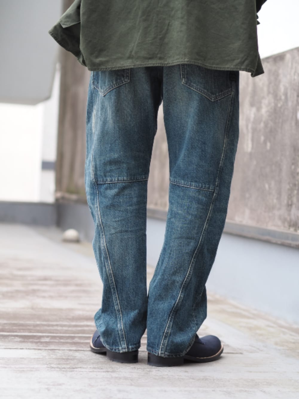 グリーン系のミリタリージャケット、ブルー系のデニムパンツを着用したメンズの春コーディネートの4枚目の写真