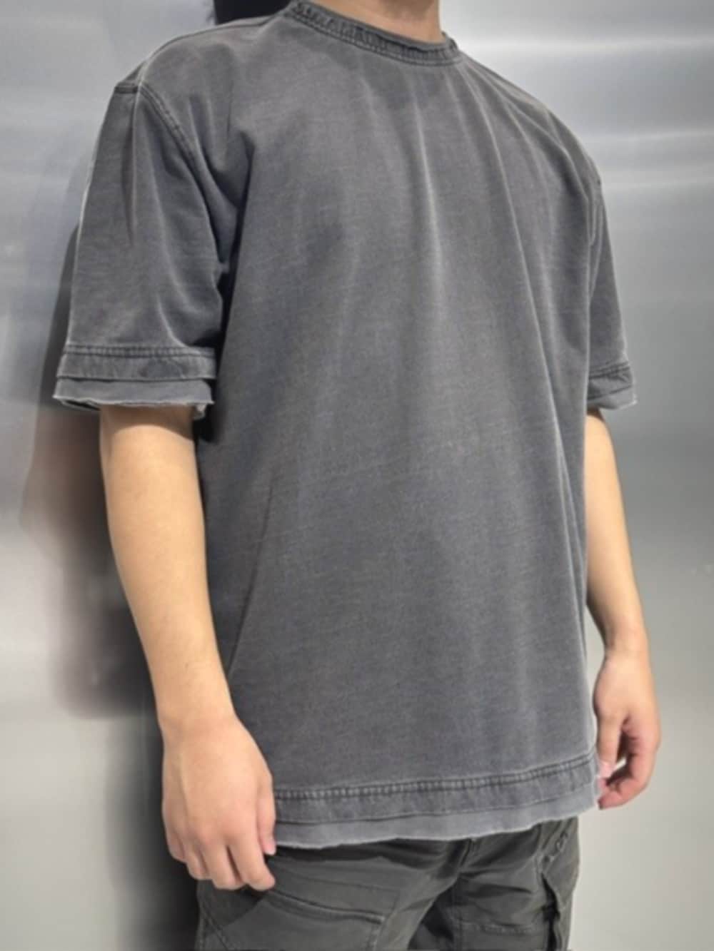 ブラック系のスニーカー、ブラック系のTシャツ/カットソー、グレー系のカーゴパンツを着用したメンズの夏コーディネートの2枚目の写真